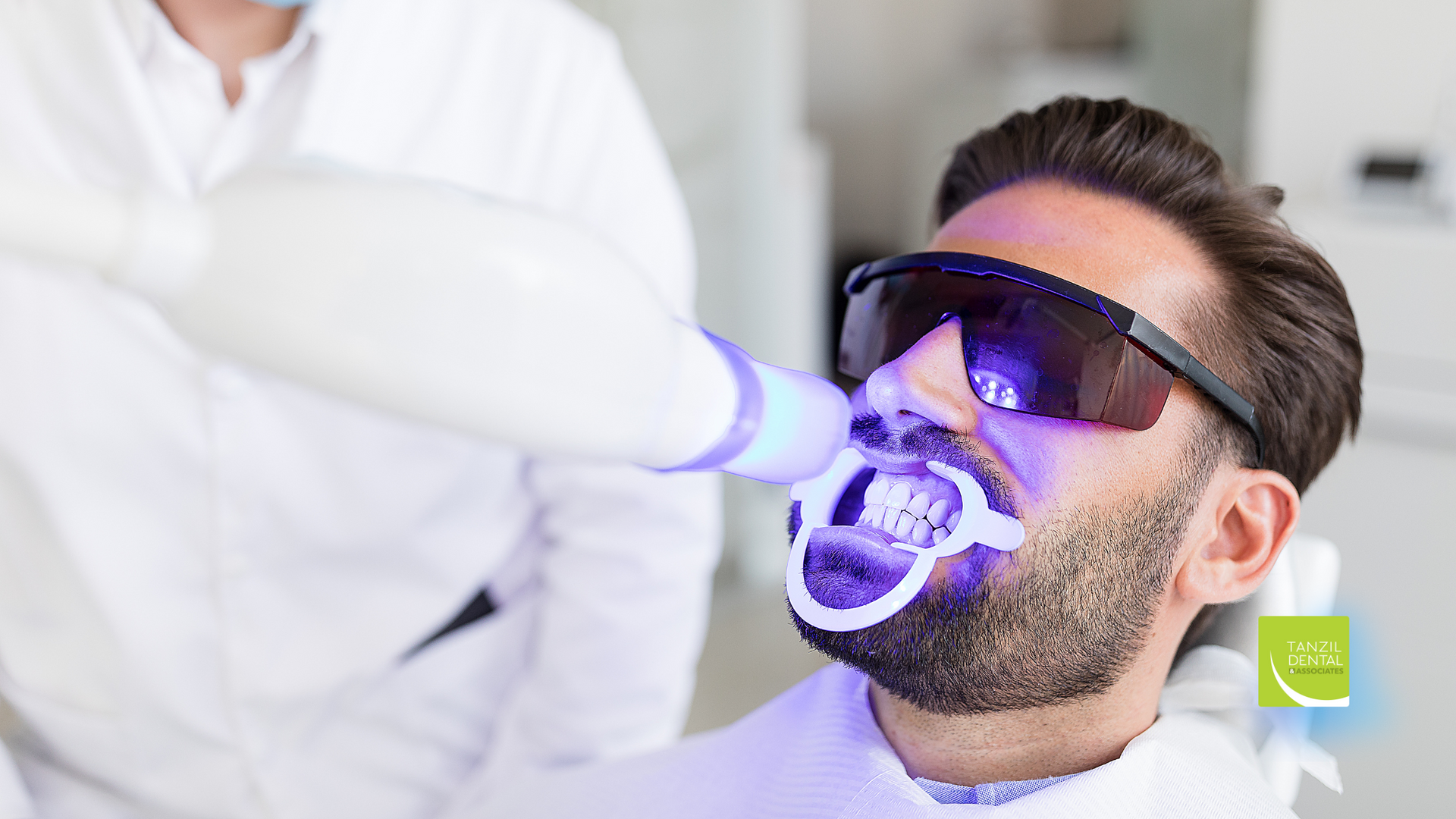 A man is getting his teeth whitened by a dentist.