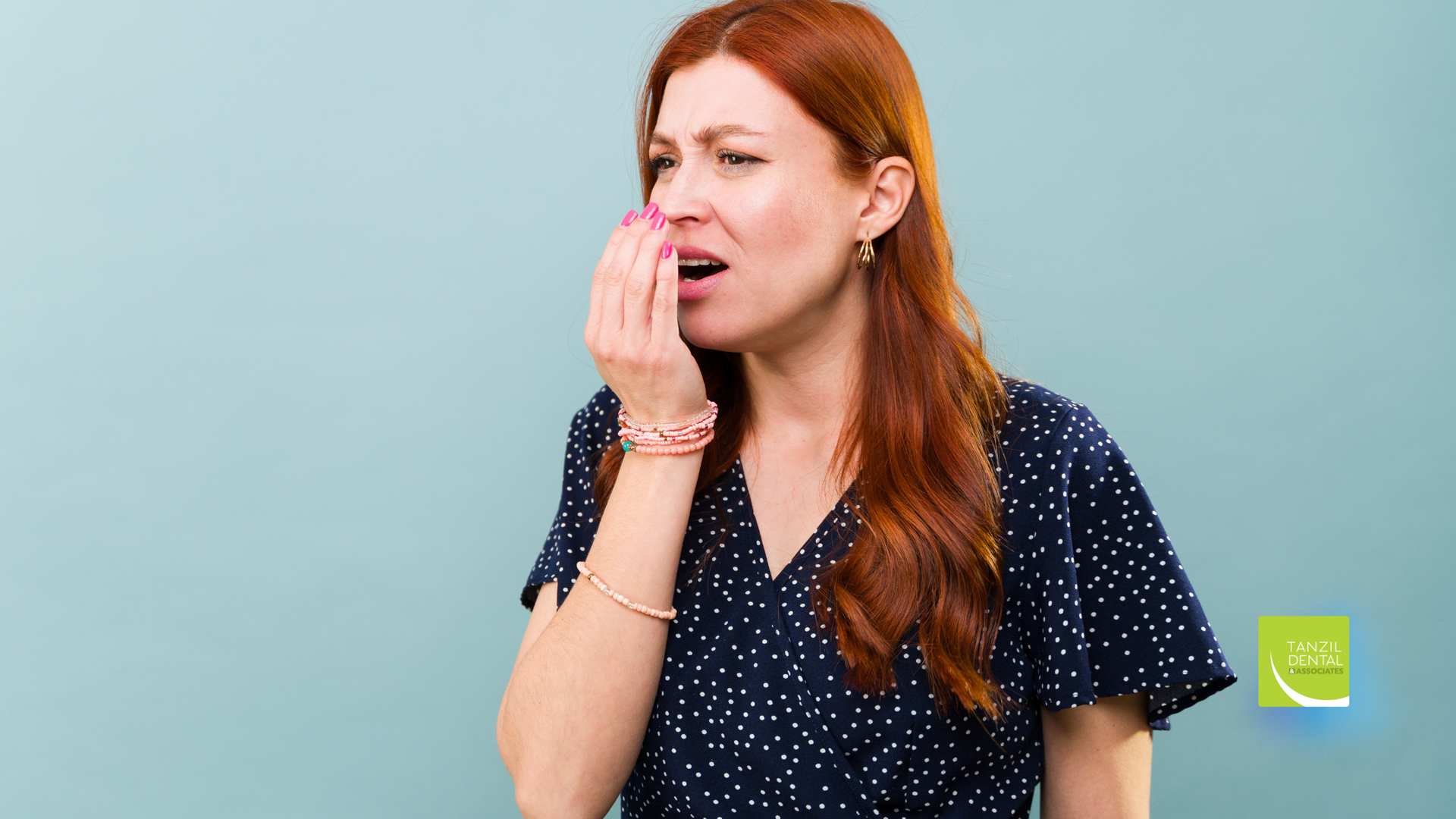 A woman is covering her mouth with her hand.