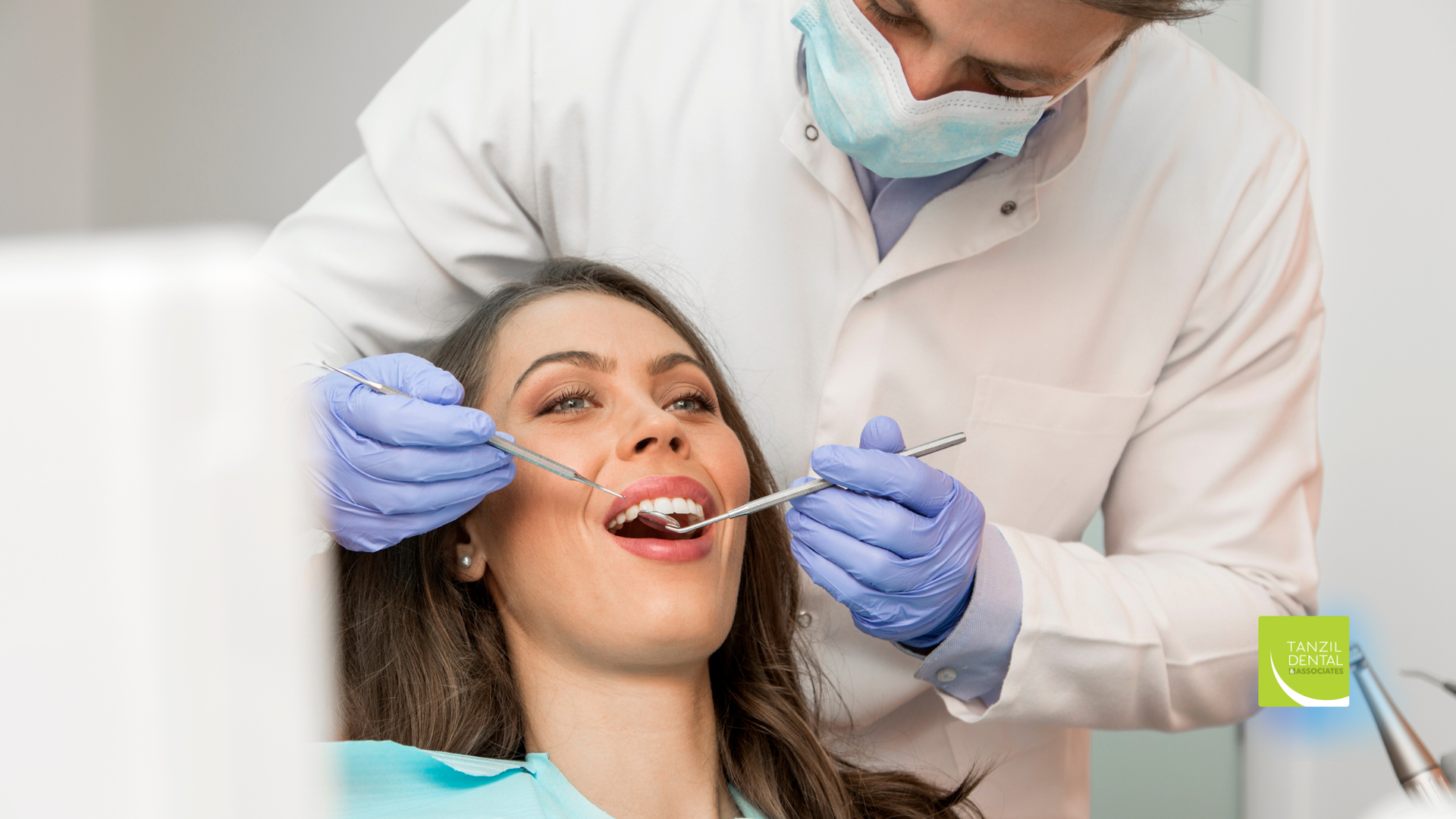 Dentist examining a patient's teeth. The patient is in a dental chair with mouth open.