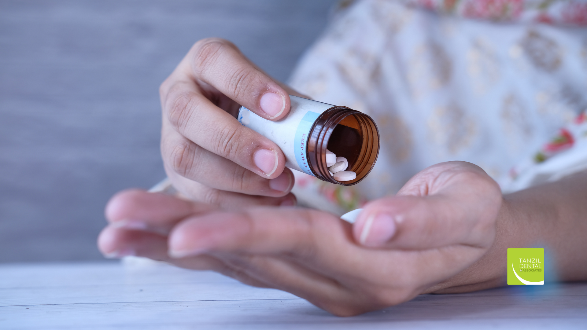 A person is pouring pills from a bottle into their hand.