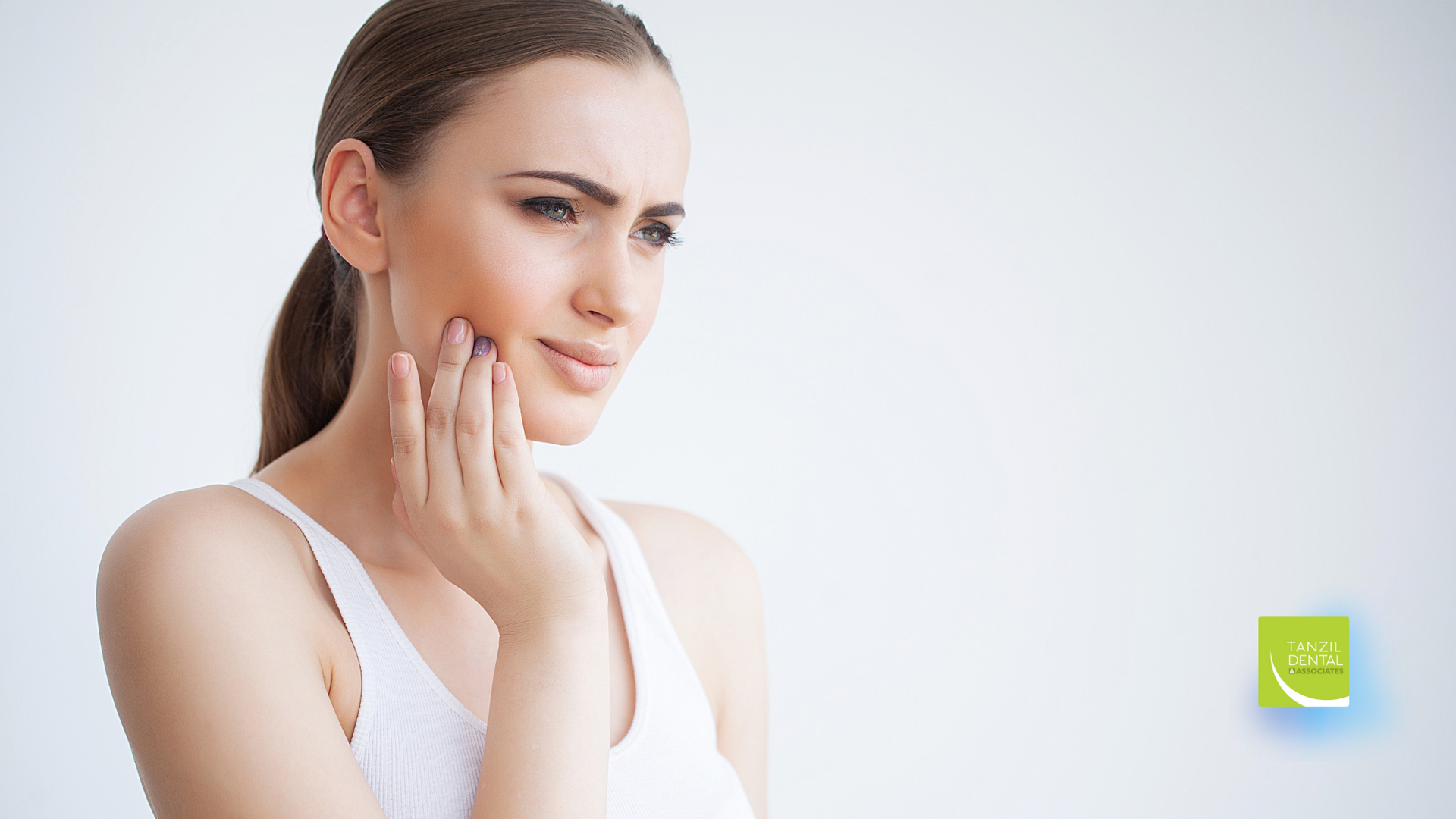 A woman is holding her face in pain because of a toothache.