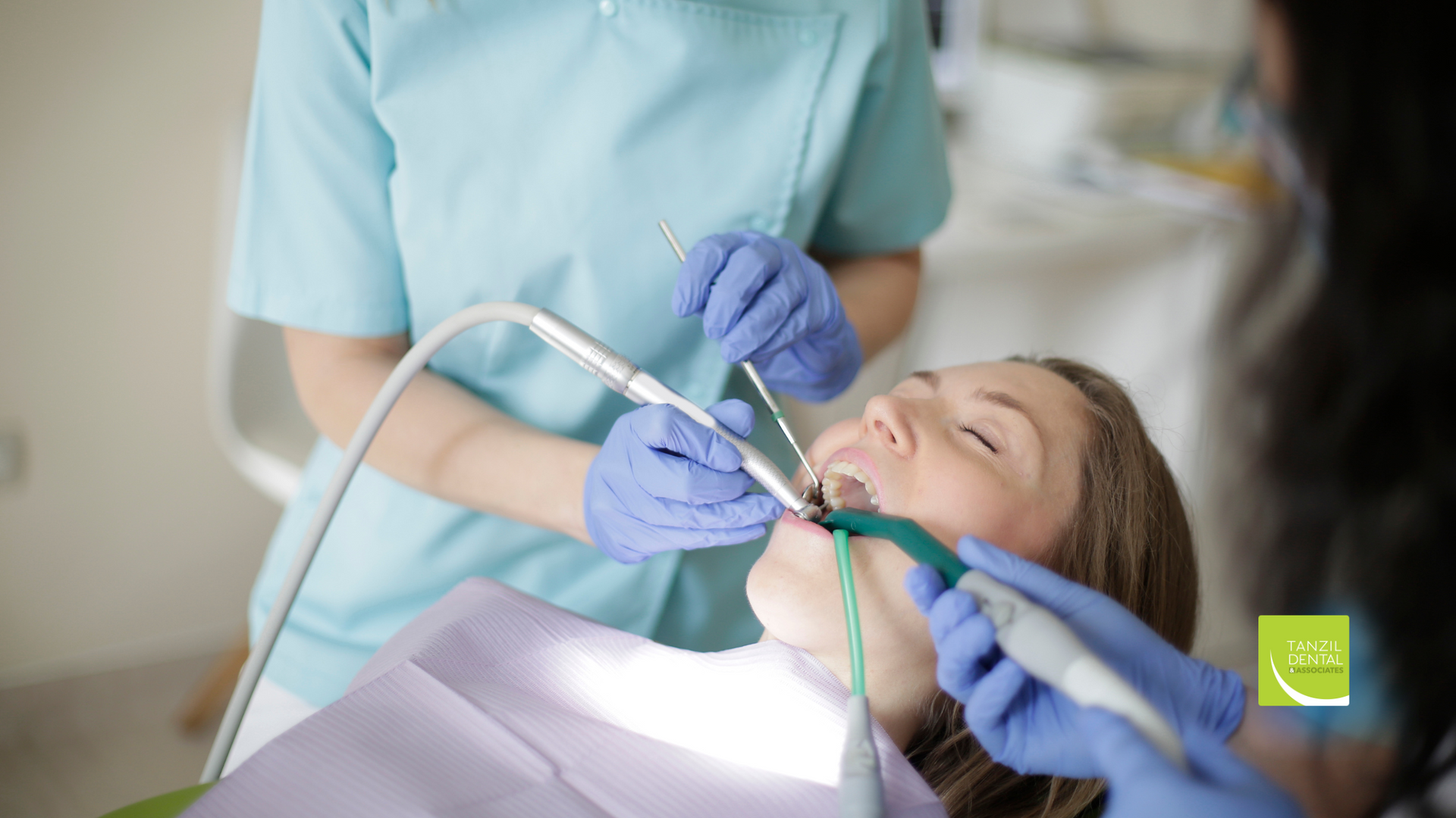 A woman is getting her teeth examined by a dentist.