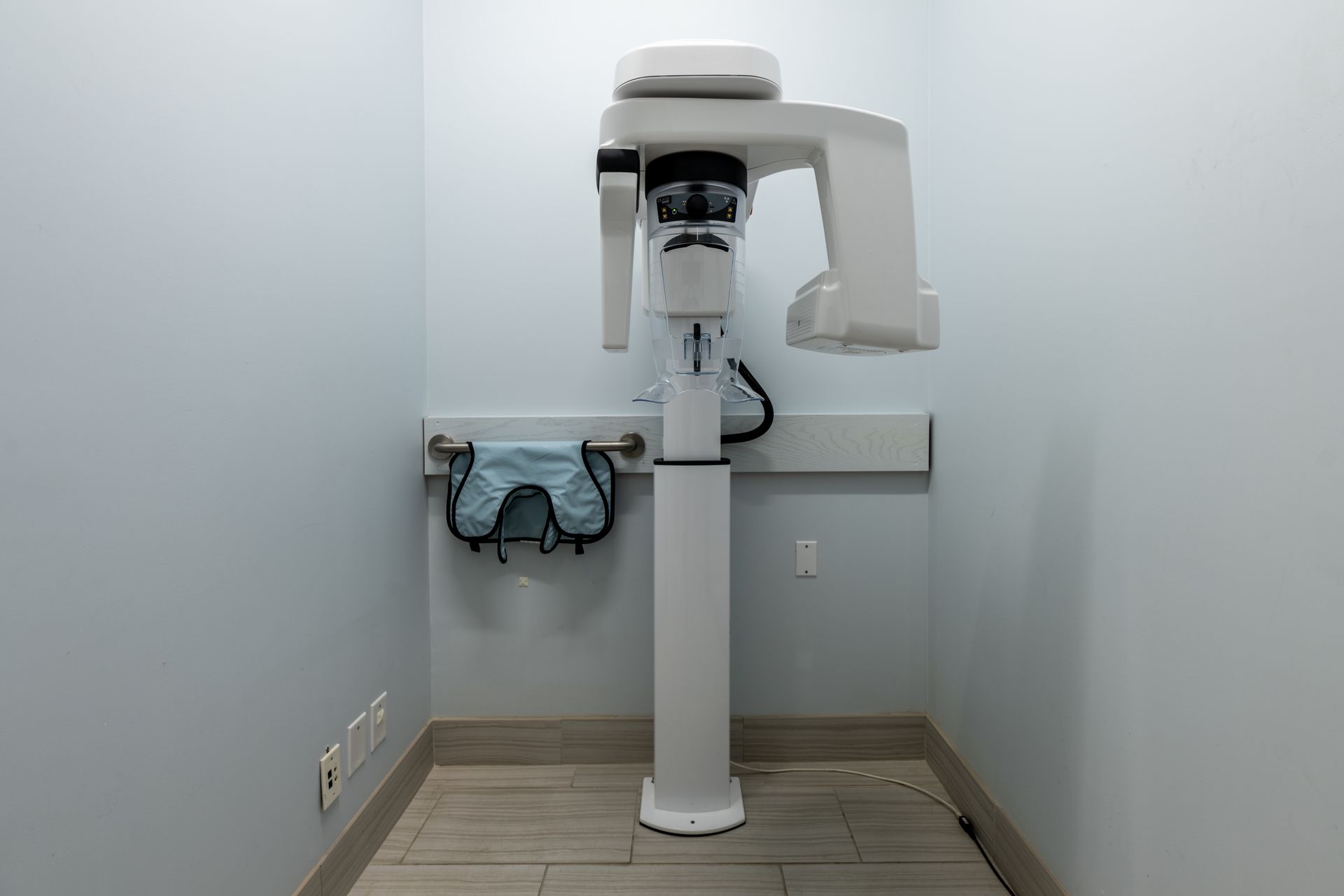 A dental x-ray machine is sitting in a small room.
