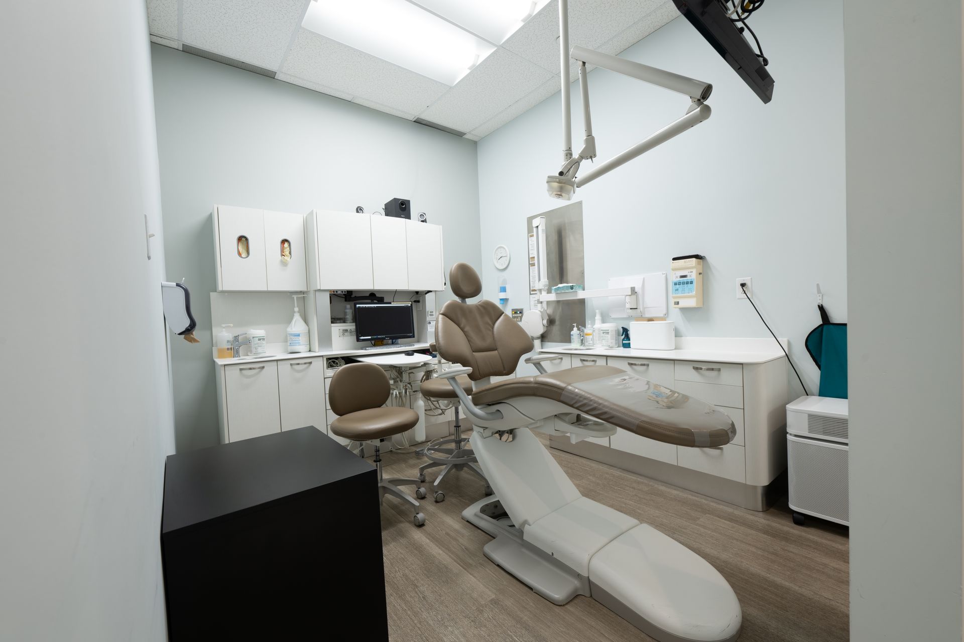 A dental office with a dental chair and a desk.