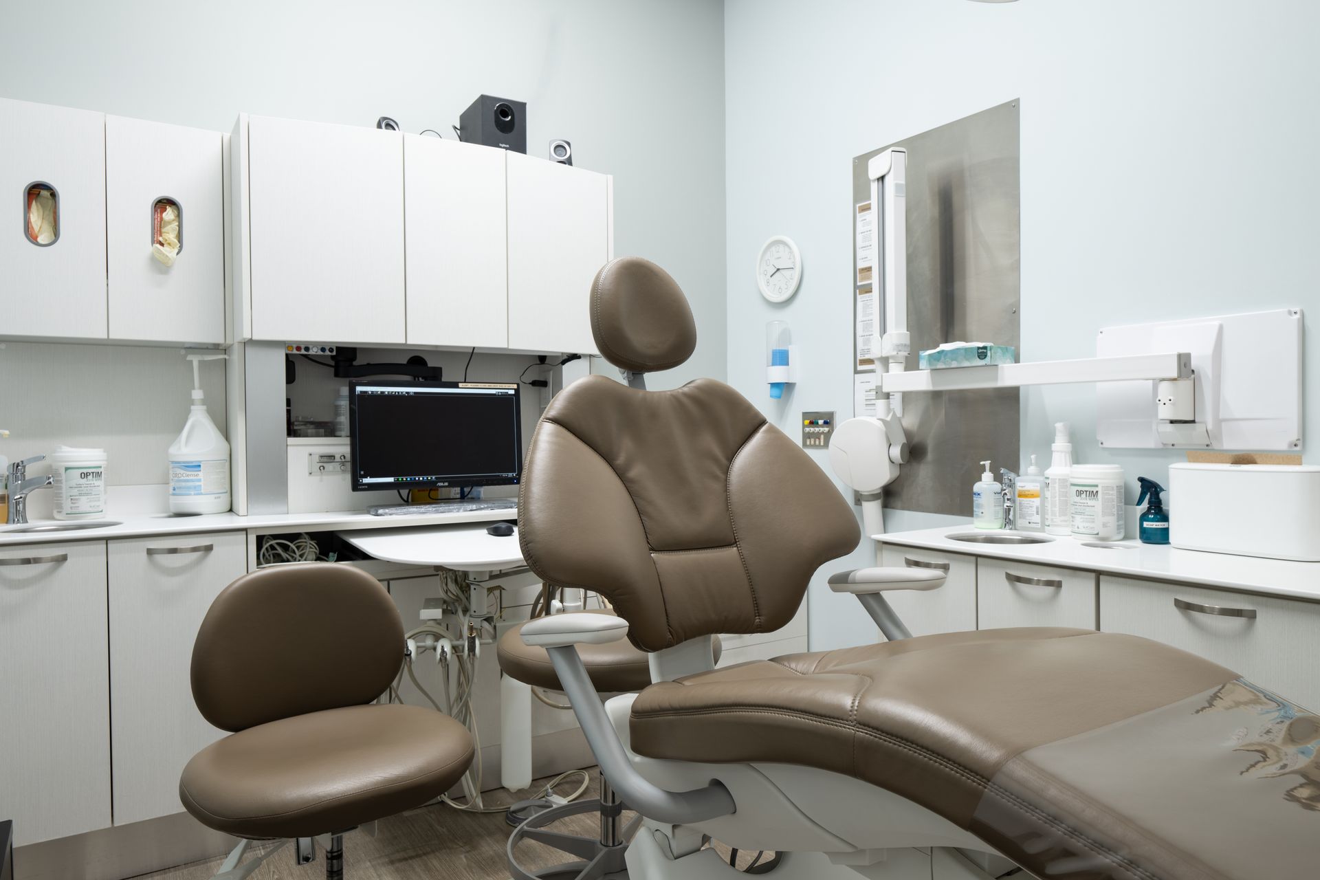 A dental office with a dental chair and a computer.
