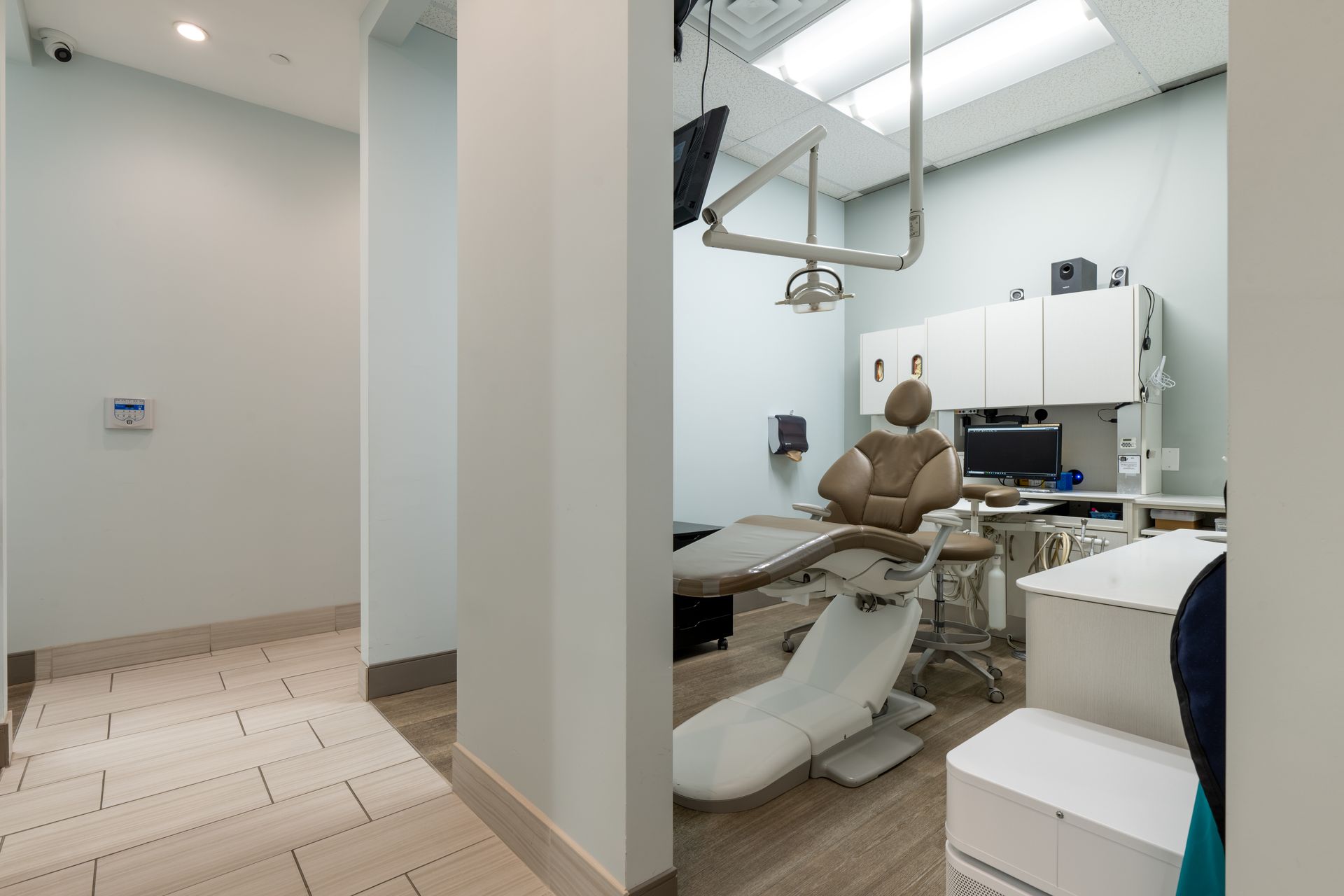 A dental office with a dental chair and a desk.