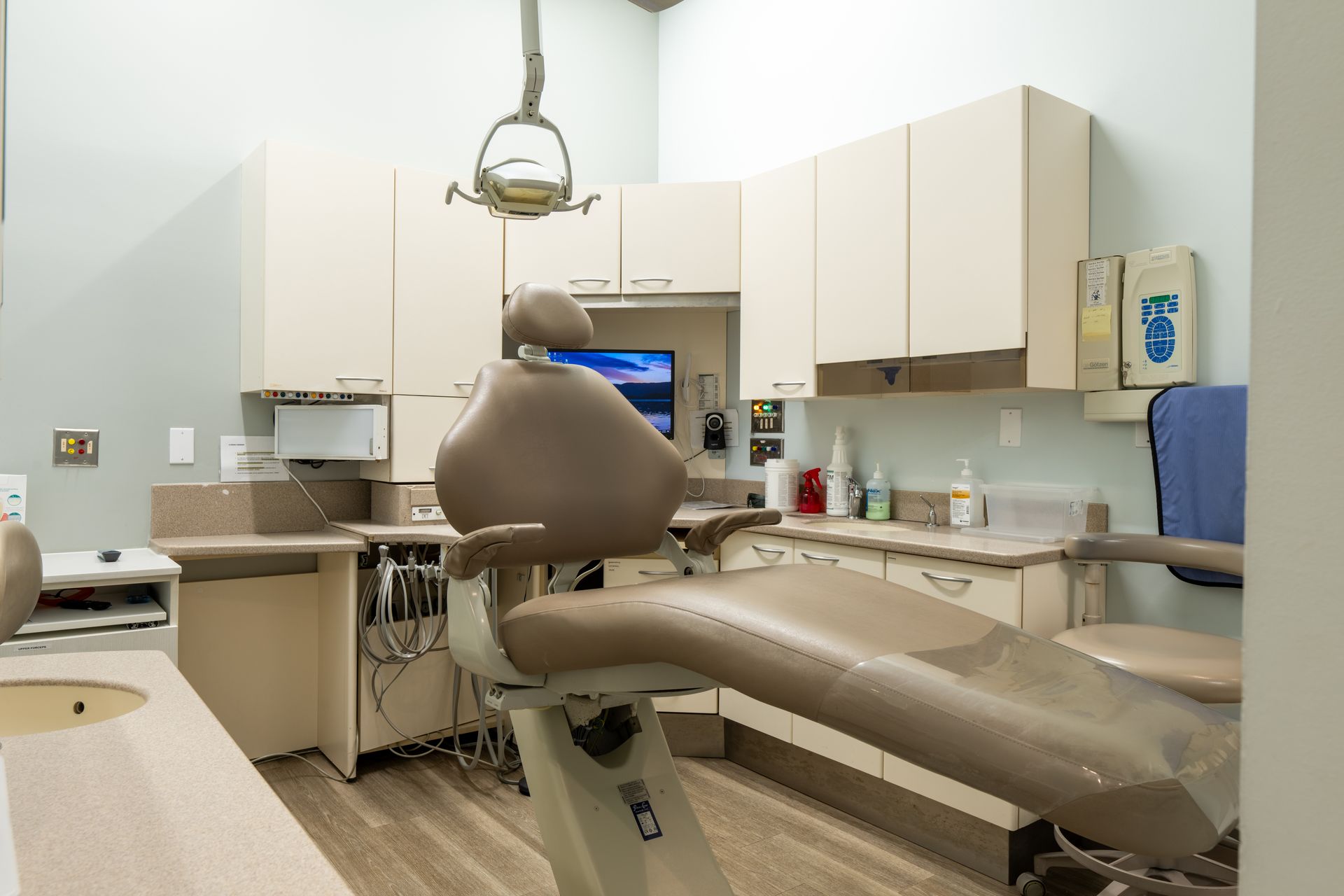 A dental office with a dental chair and a sink.
