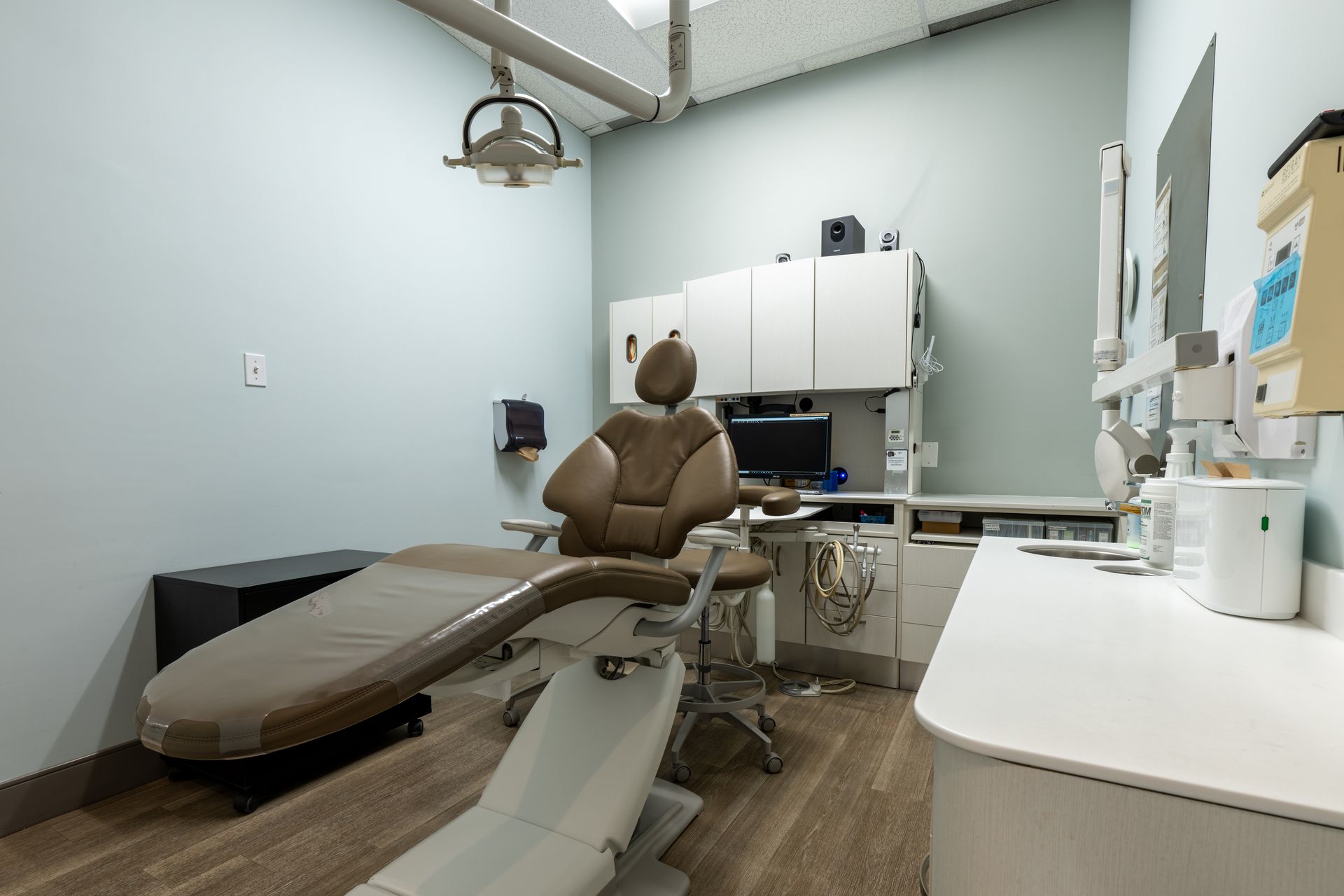 A dental office with a dental chair and a desk.