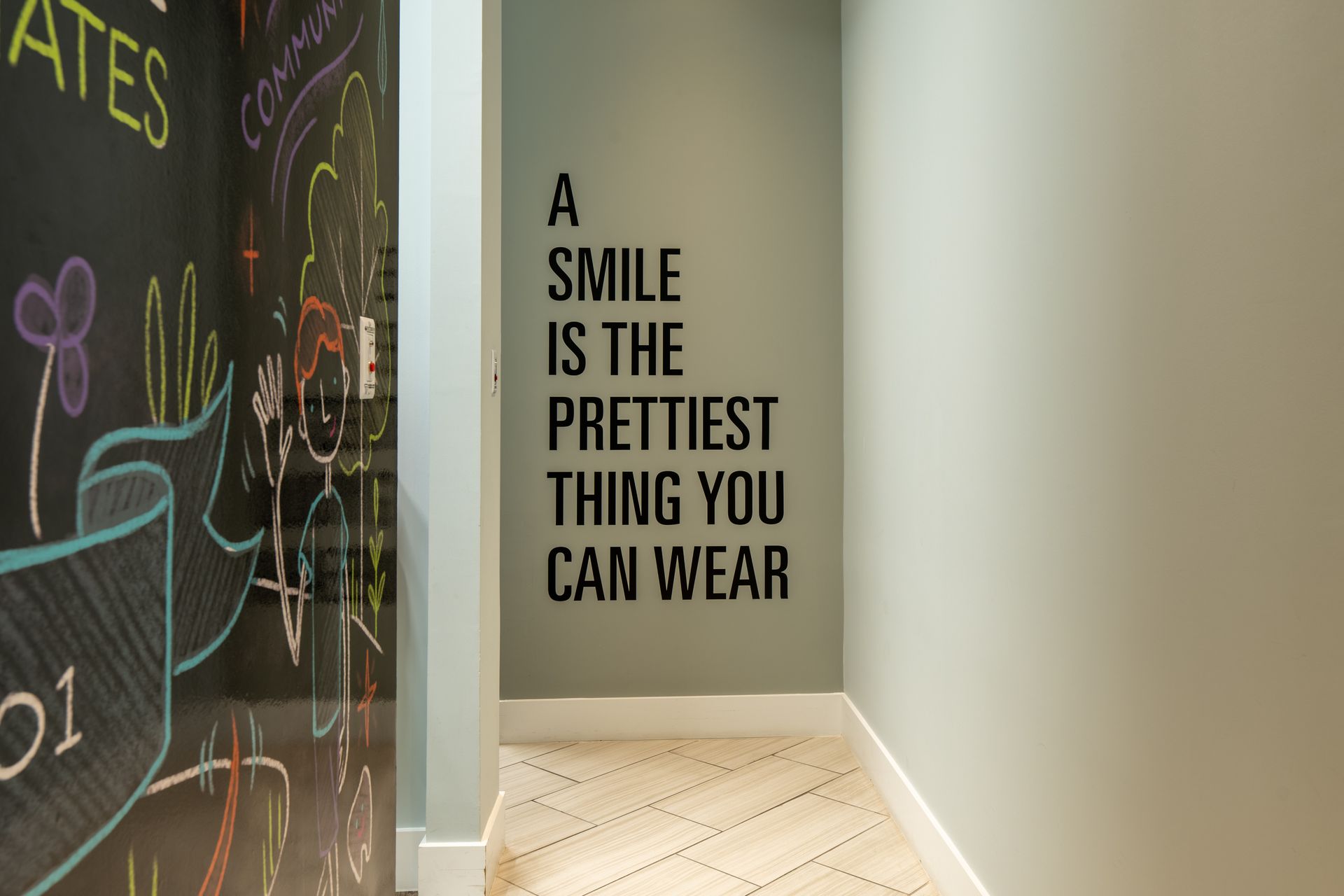 A smile is the prettiest thing you can wear written on a wall