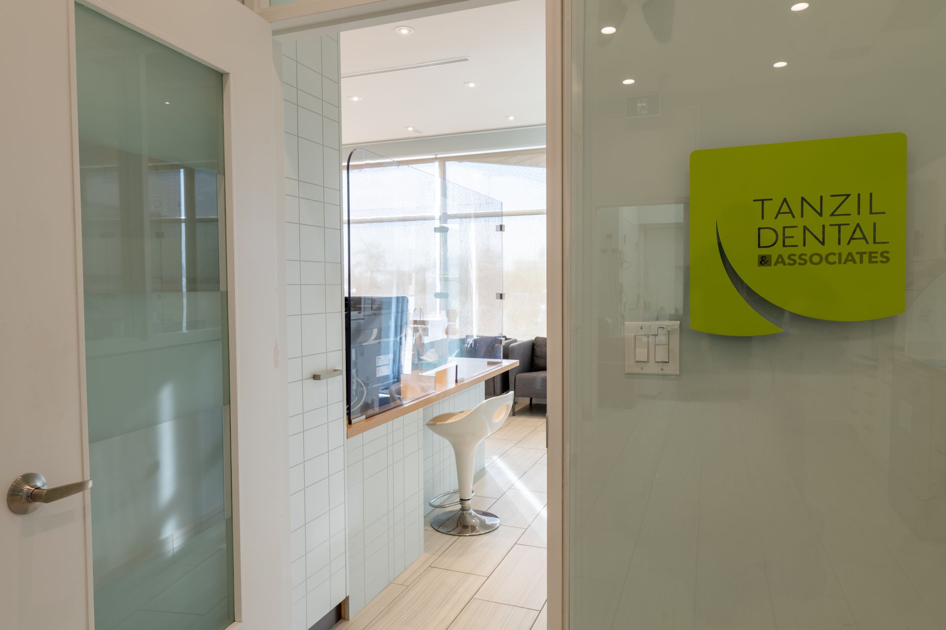 A dental office with a green sign on the door that says tanzil dental associates.