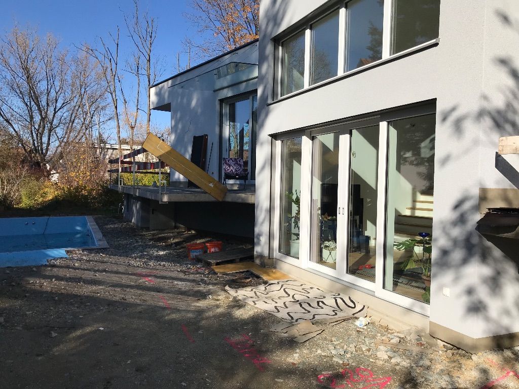 ein weißes Haus mit vielen Fenstern und einem Pool dahinter