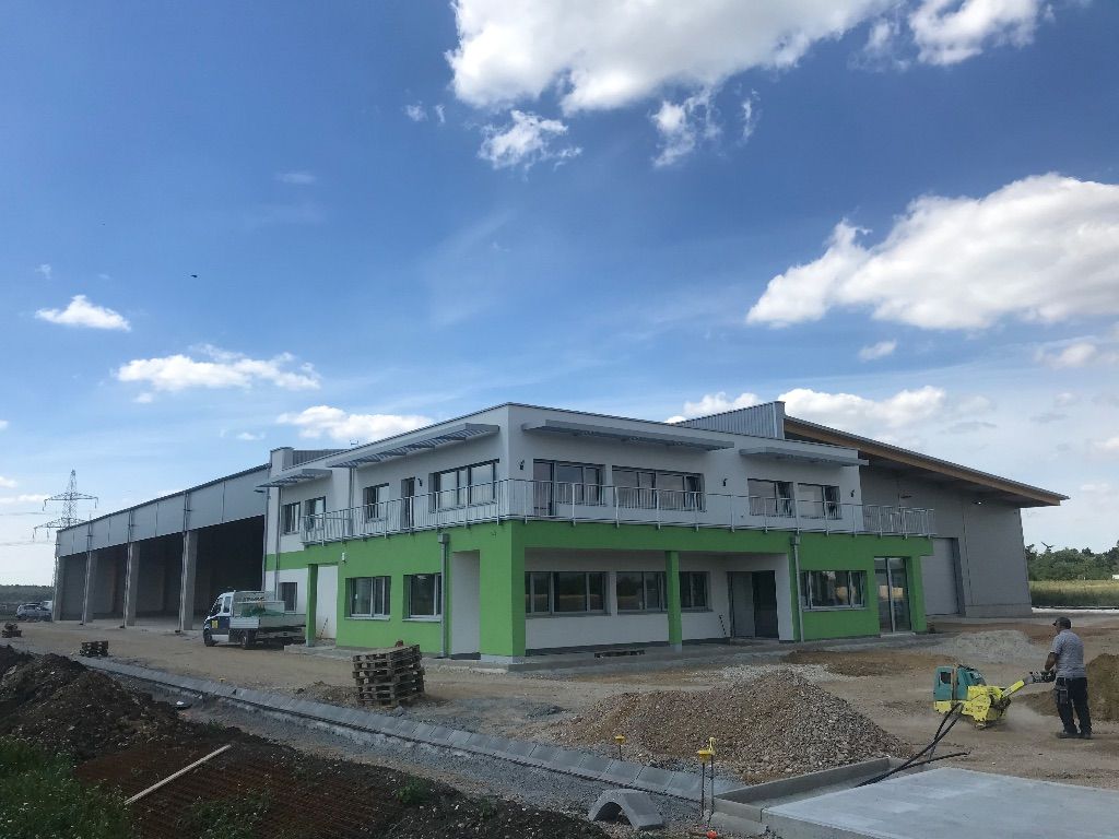 ein großes Gebäude mit grünen Fenstern und einem Balkon