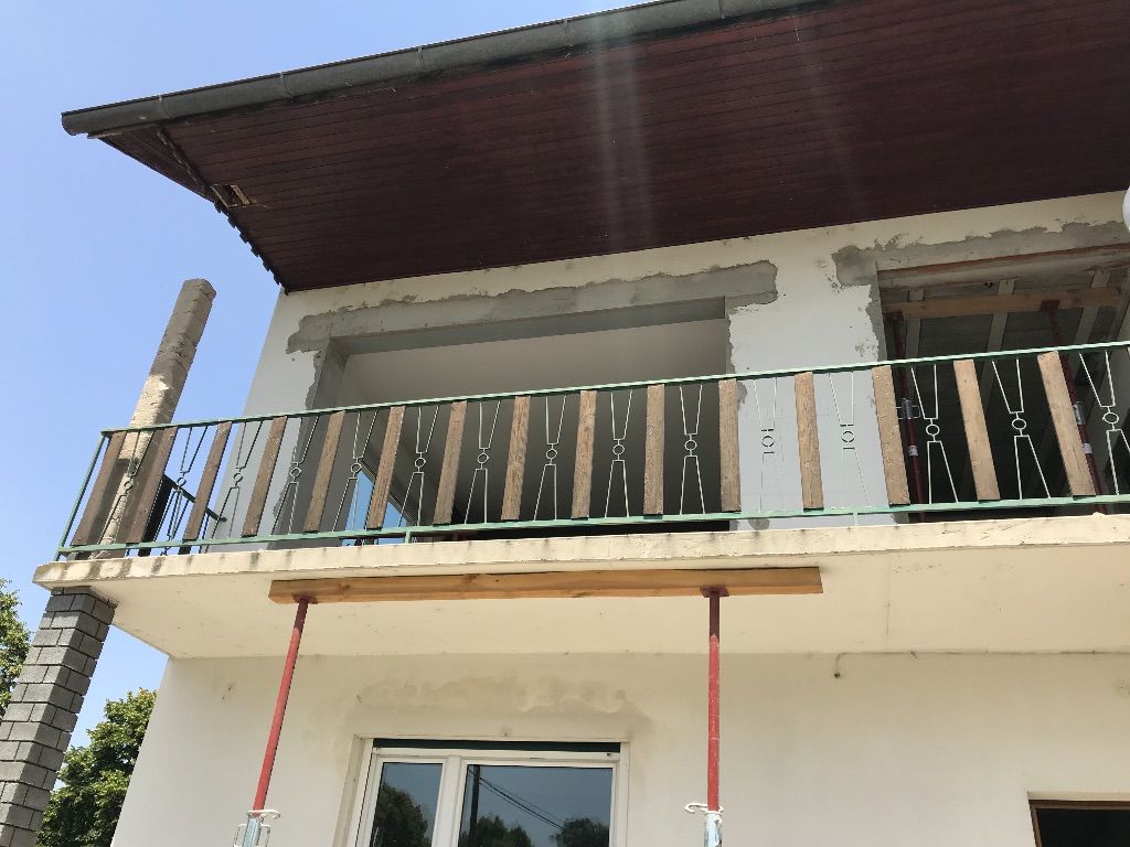 ein weißes Haus mit einem Balkon und einem Fenster