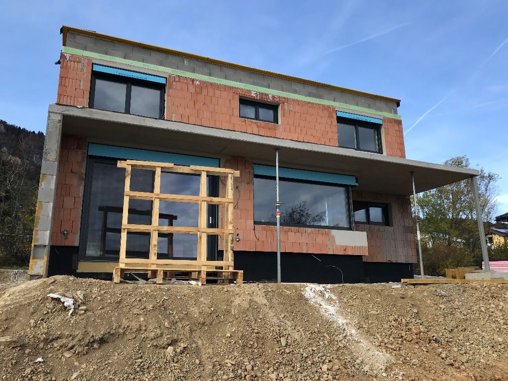 ein braunes Backsteingebäude mit vielen Fenstern wird gebaut