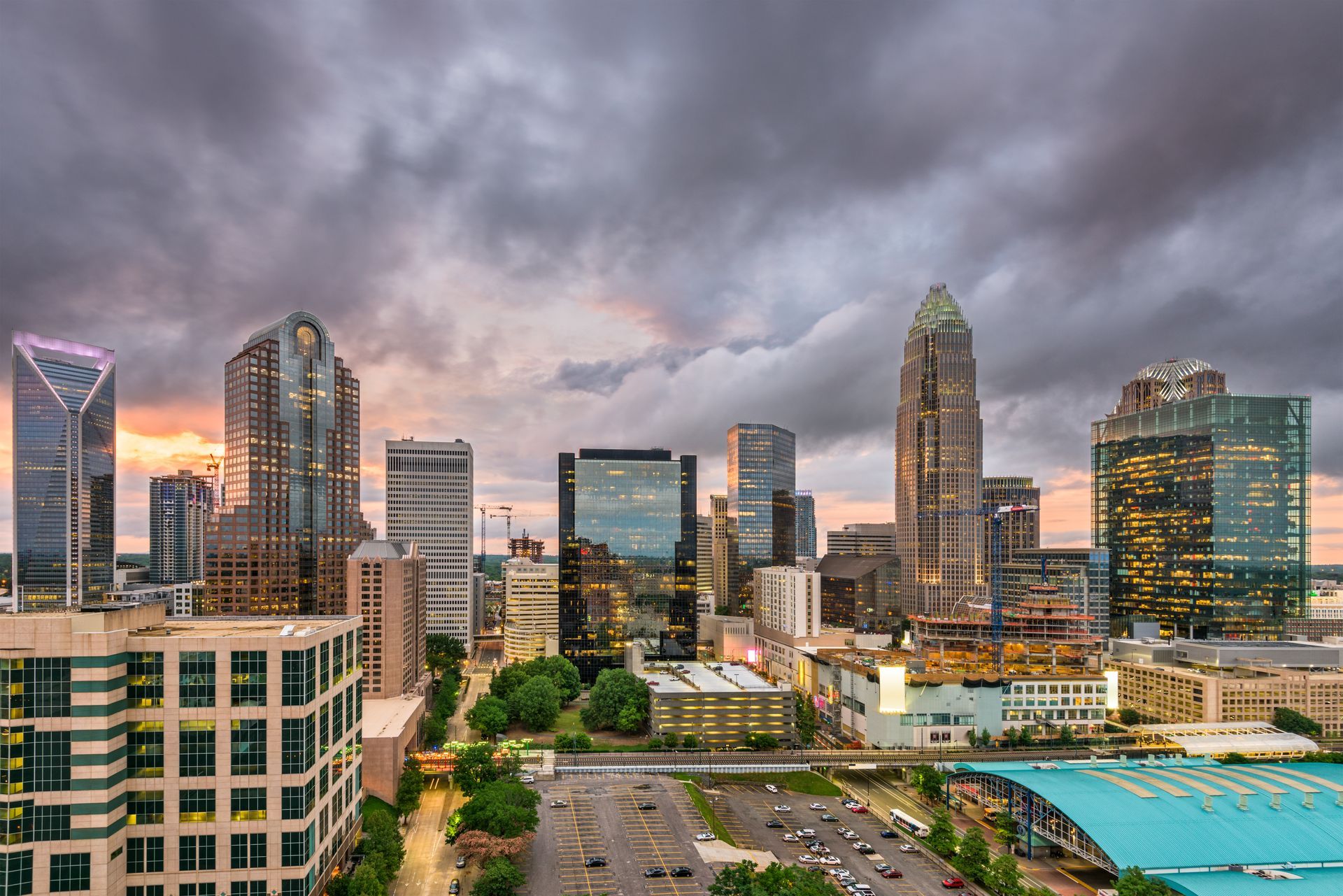 Charlotte, North Carolina skyline at dusk, showcasing tall buildings against a cloudy sky.
