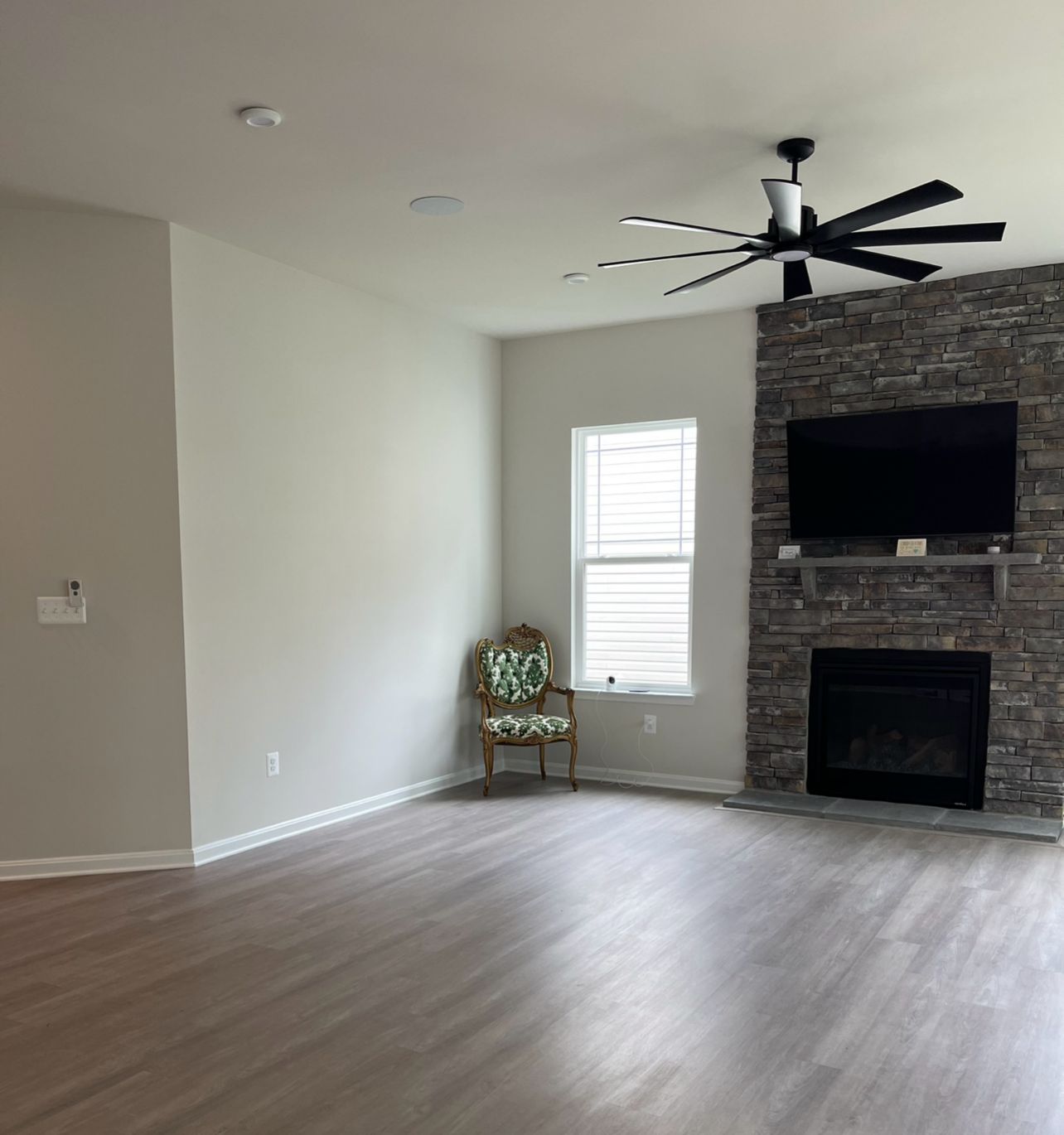 Ceiling fan and recessed lighting installed in remodeled living room with fireplace