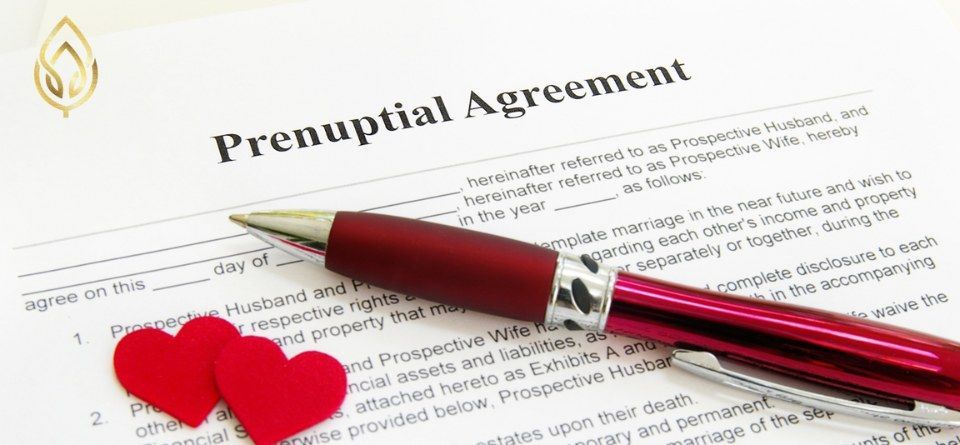 Prenuptial agreement document with red pen and two red hearts on a white background