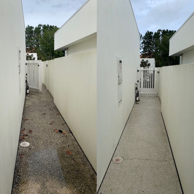 A Person Is Cleaning A Concrete Driveway With A Machine — Supercare Gold Coast in Miami, QLD