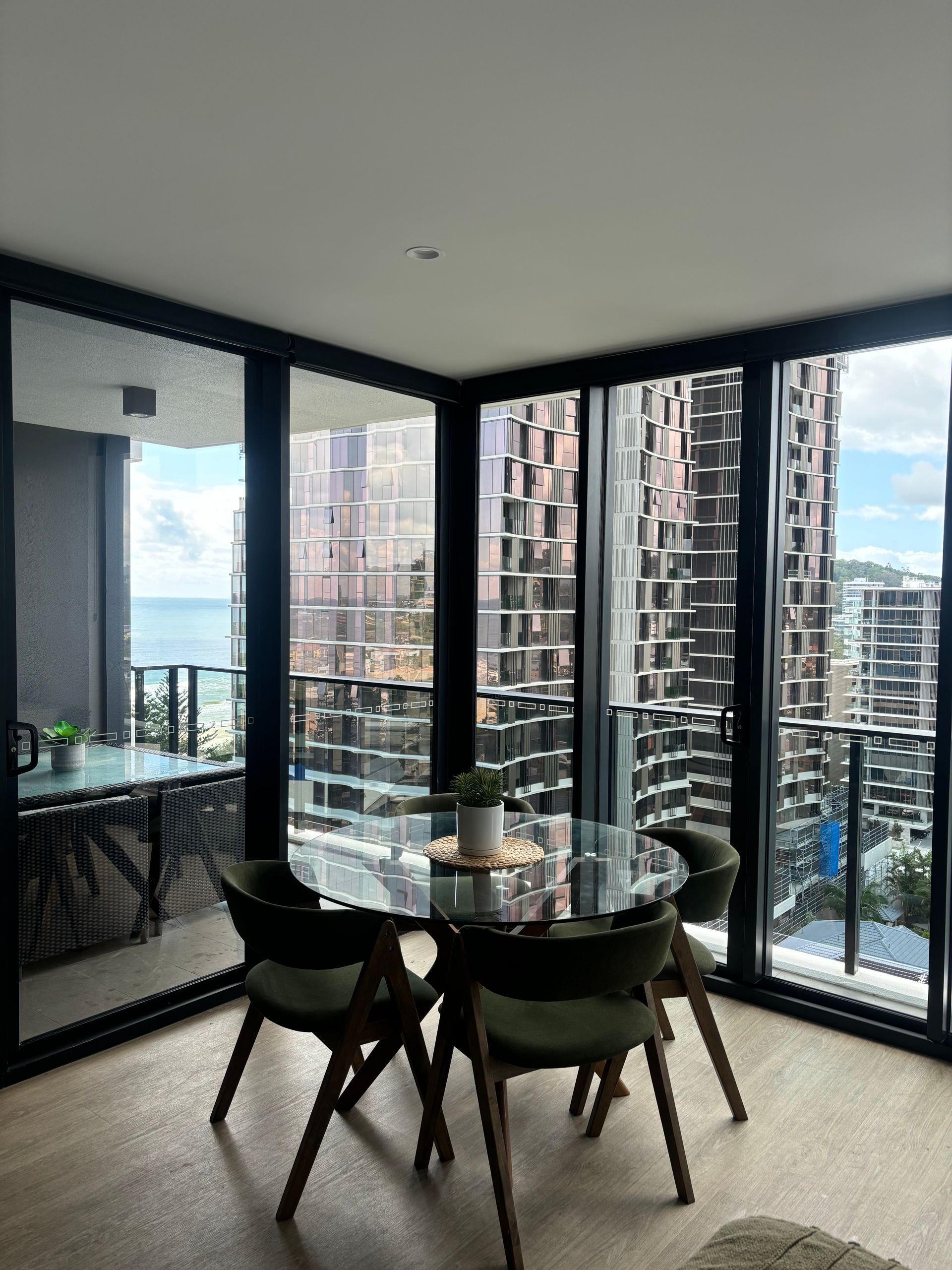 A Dining Room Table With Clean Glass Windows and View Of The City — Supercare Gold Coast in Hope Island, QLD