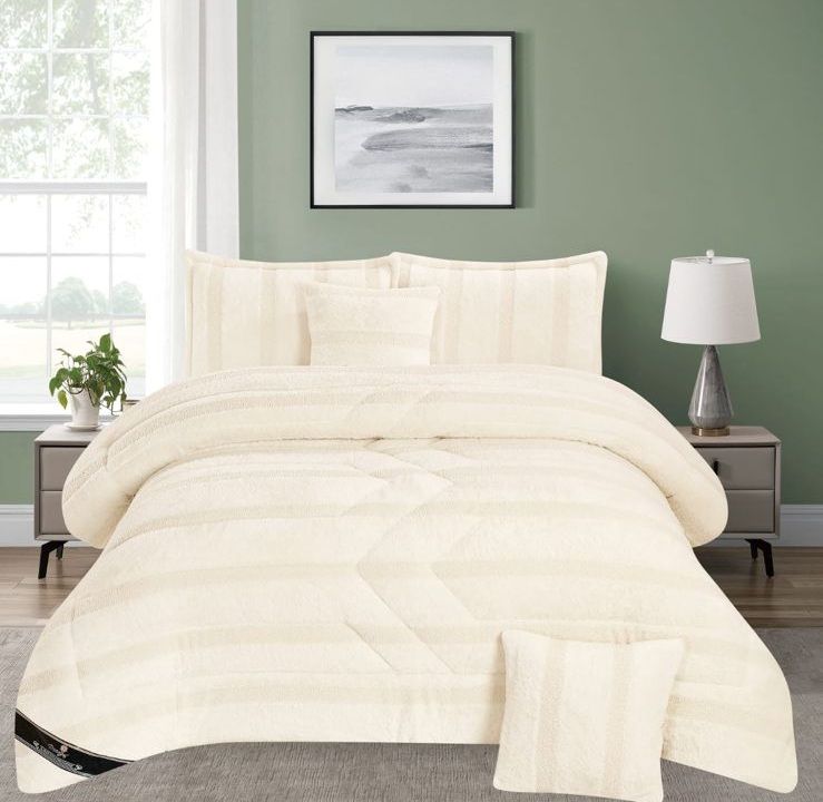 Edredón y fundas de almohada color crema sobre una cama en un dormitorio luminoso con paredes verdes y lámparas de noche.