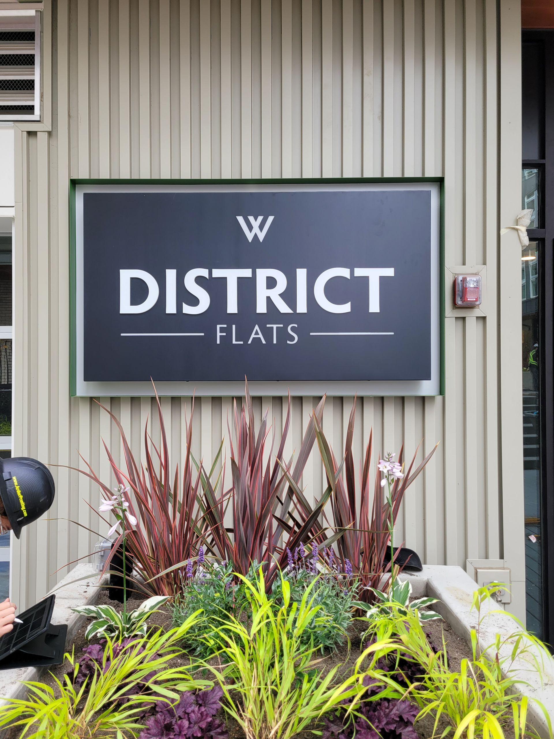 Sign for  district flats with landscaping