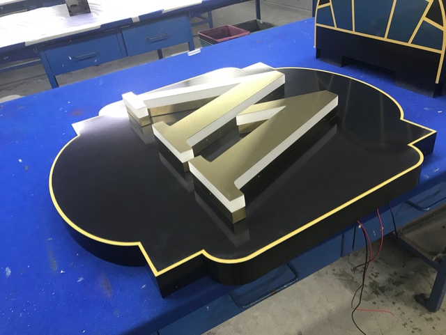 Black and gold sign with letters