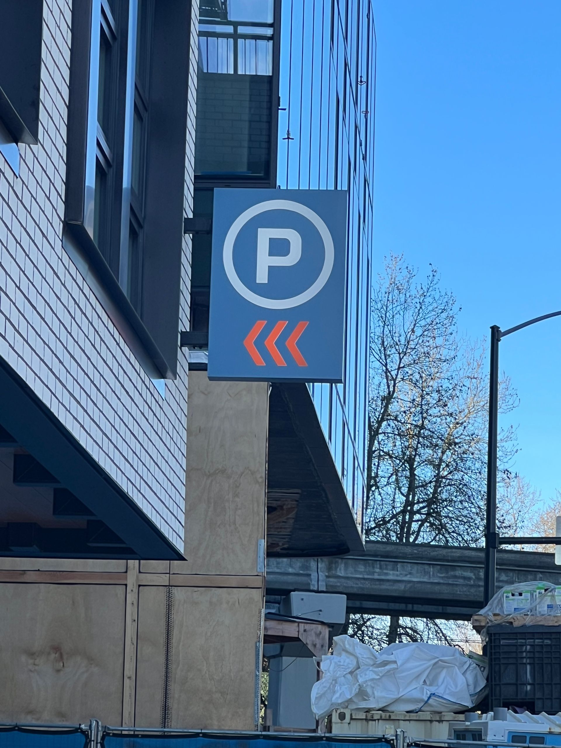 Parking sign with white and orange arrows pointing left
