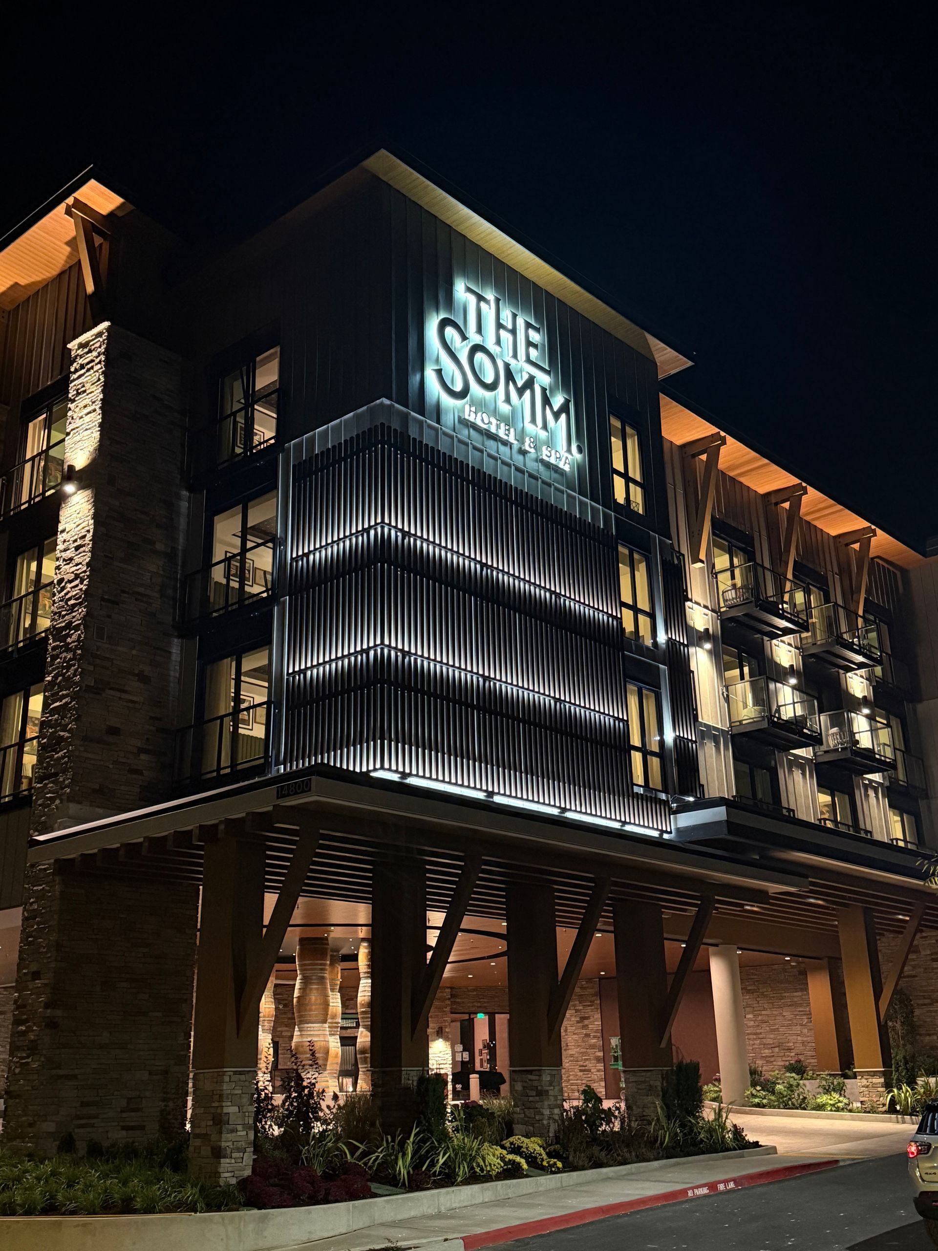 Night view of hotel with illuminated sign and entrance.