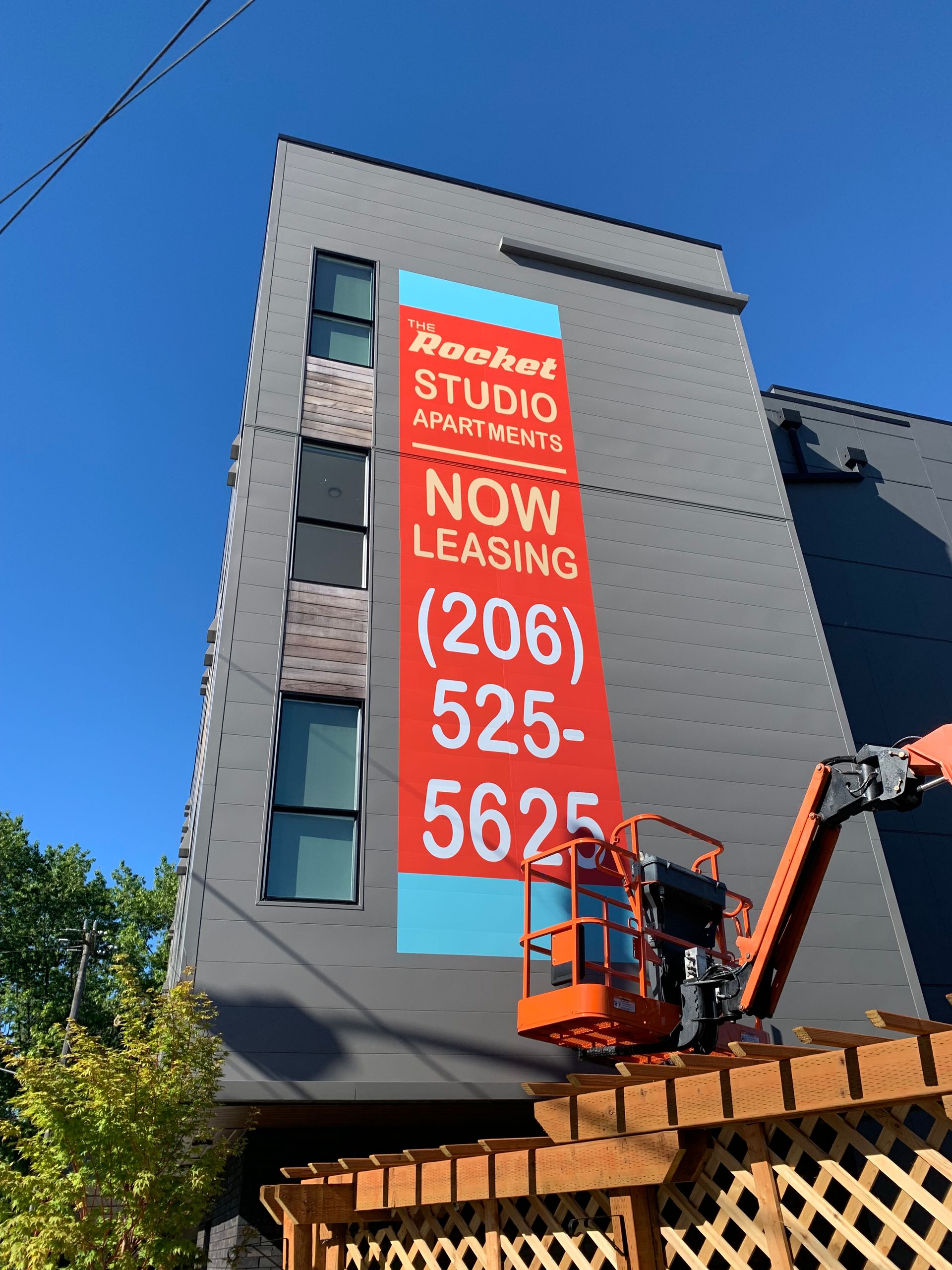 Apartment building with large sign and phone number in red