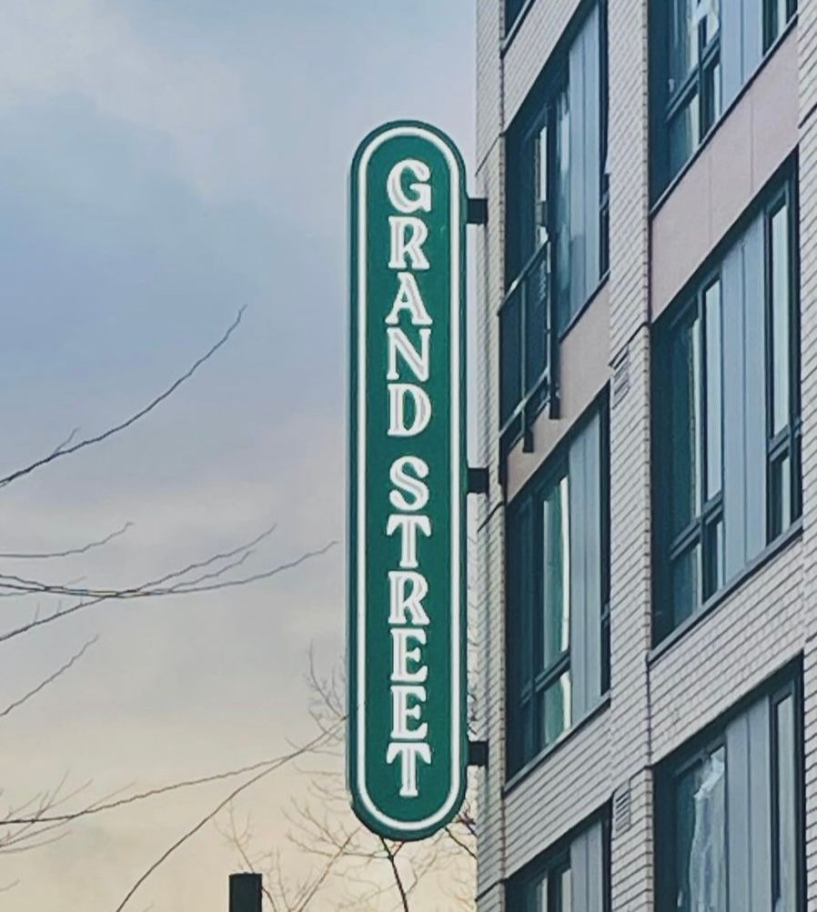 Sign in green and white, mounted on a building