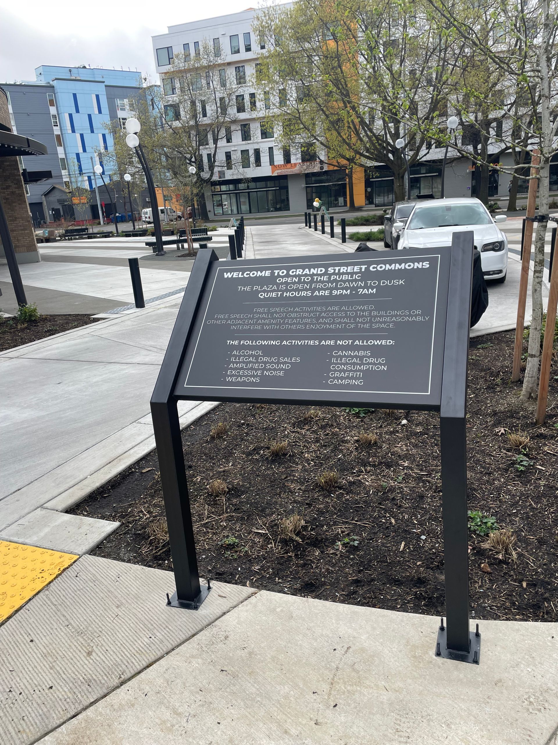 Sign with text in a park setting, black and white color scheme