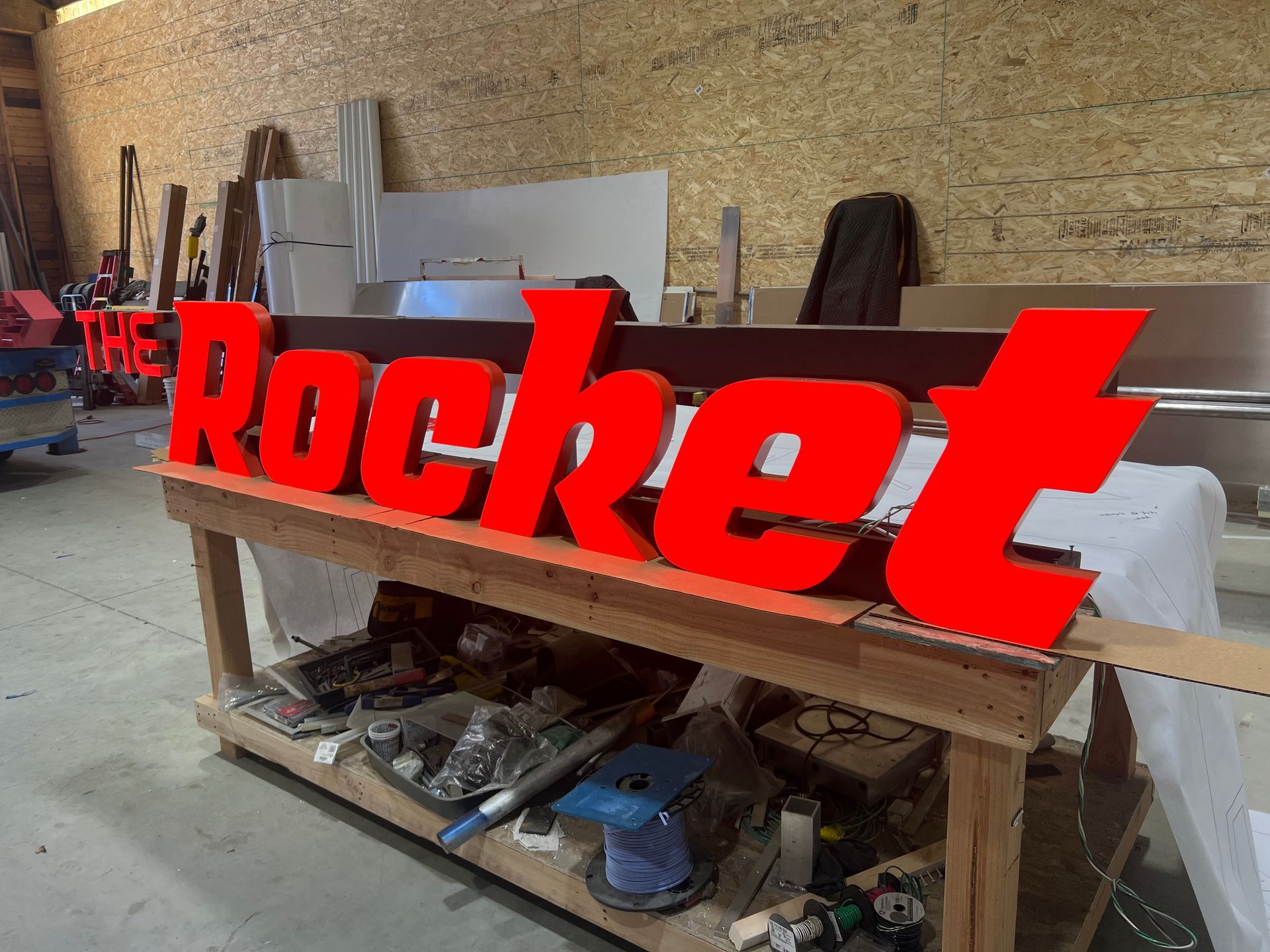 Red sign on a wooden workbench in a workshop