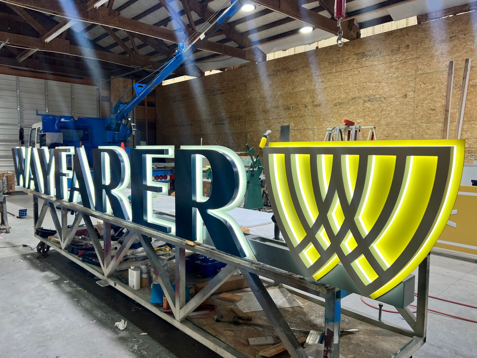 Illuminated letters and a yellow and black logo in a workshop
