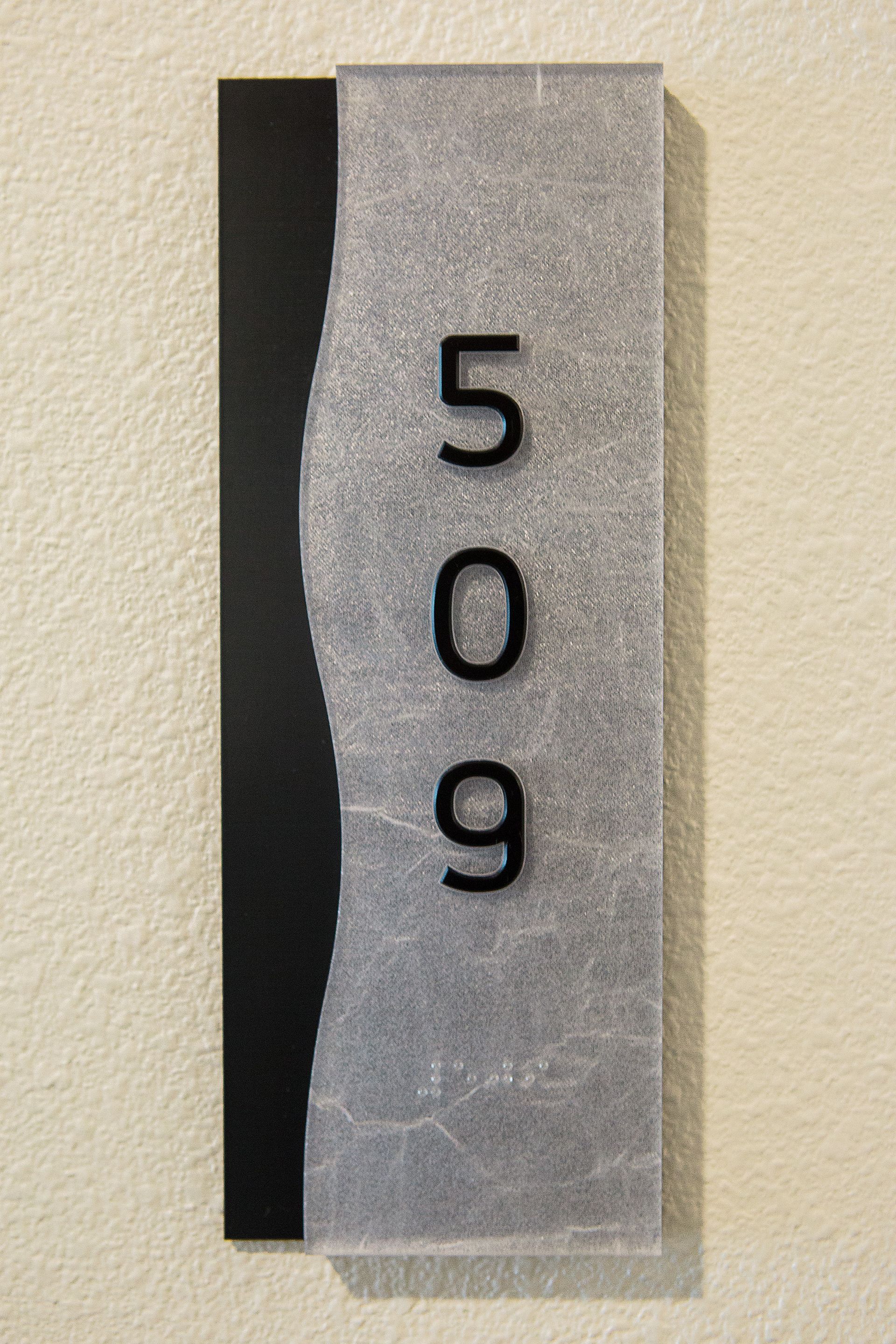 Room number sign with silver and black panels, number 509
