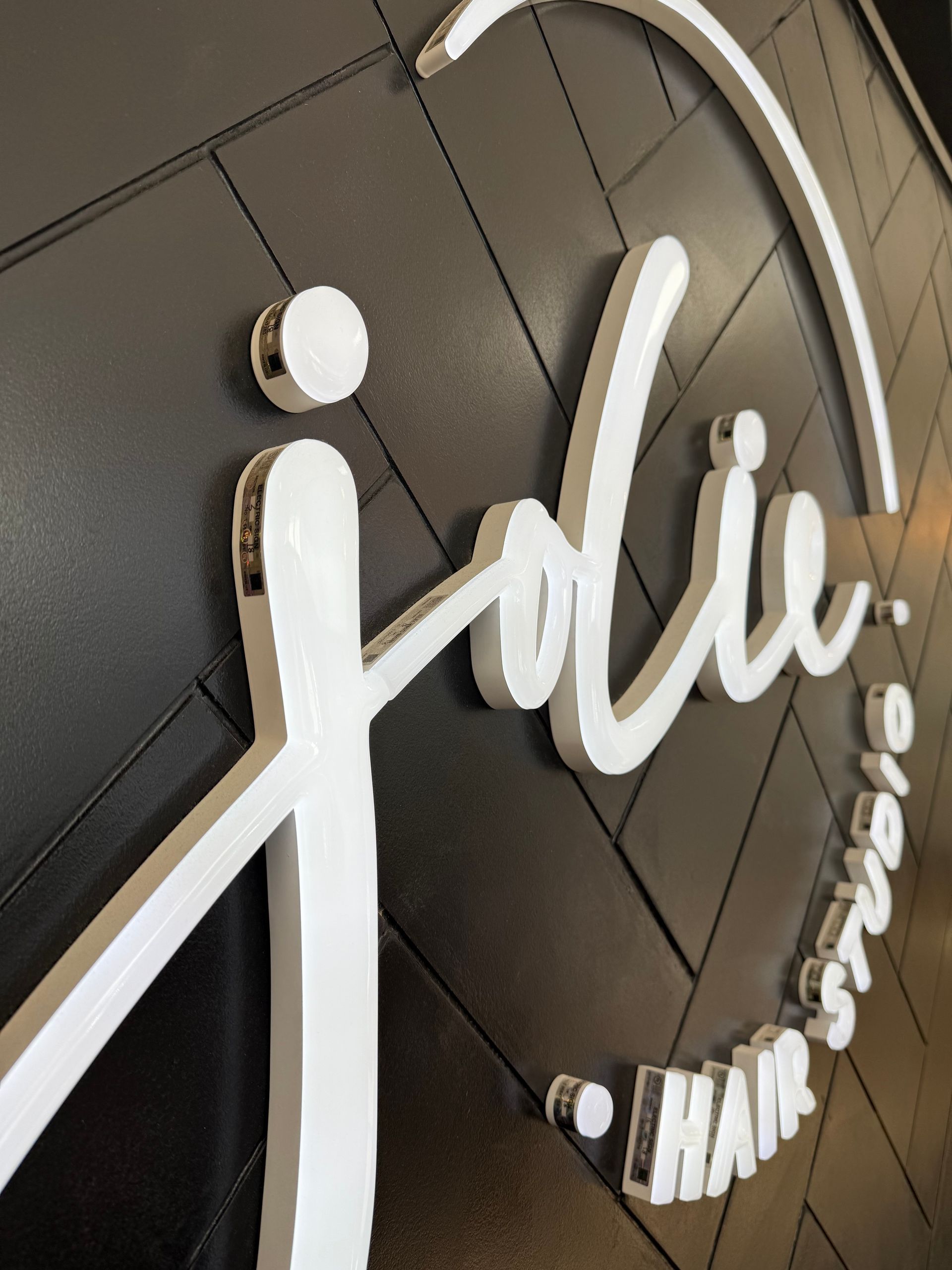 White logo on a black textured wall