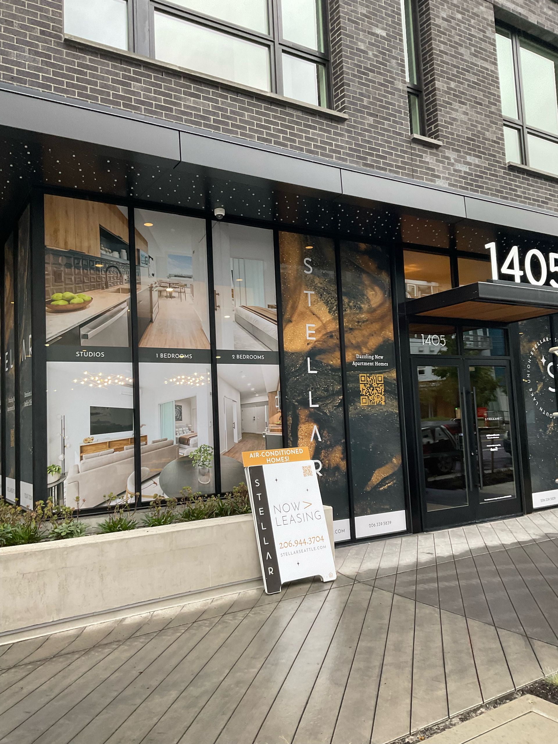 Modern building storefront with large windows displaying interior design images