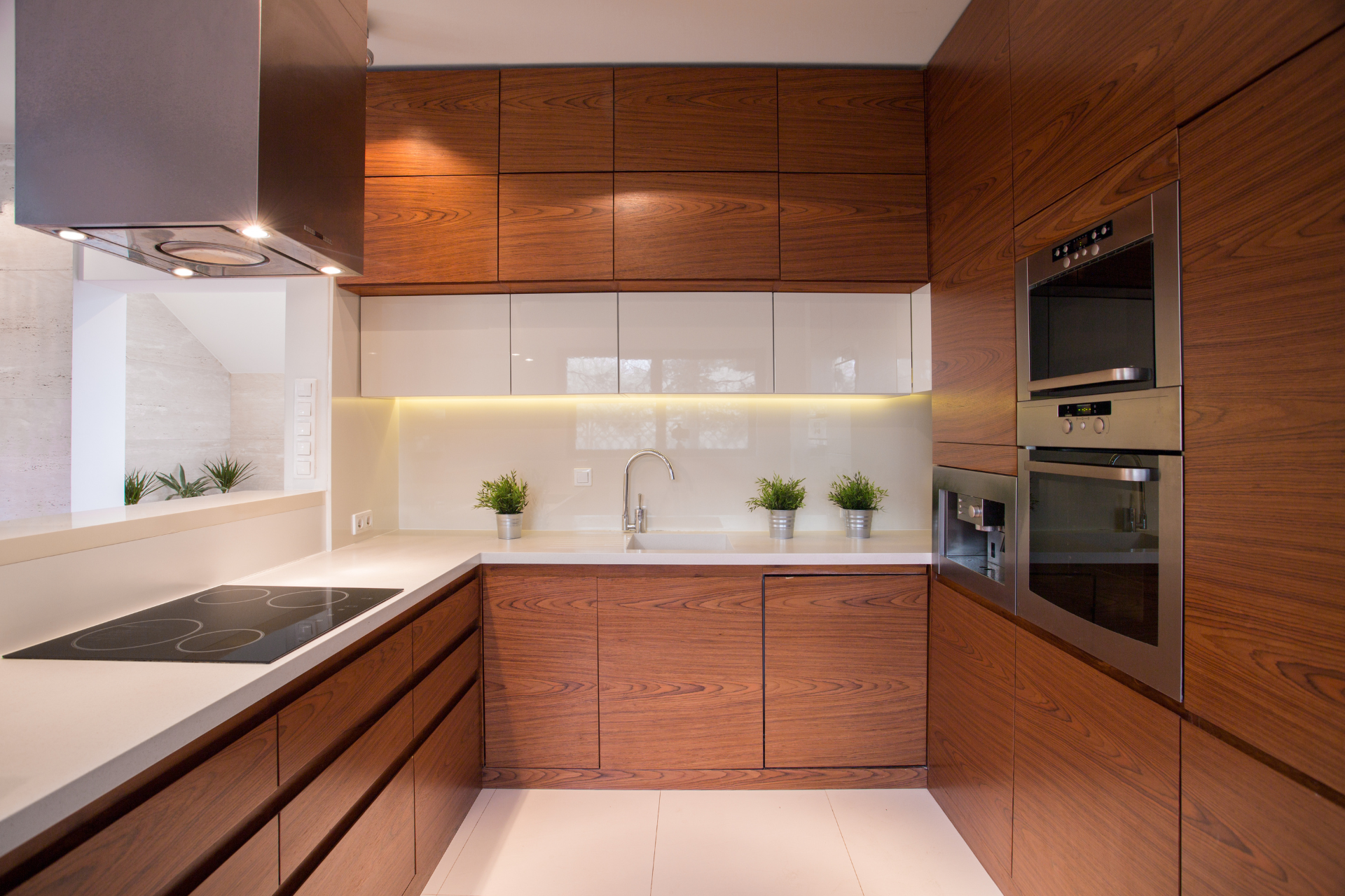 A kitchen with wooden cabinets , stainless steel appliances , and a stove top oven.