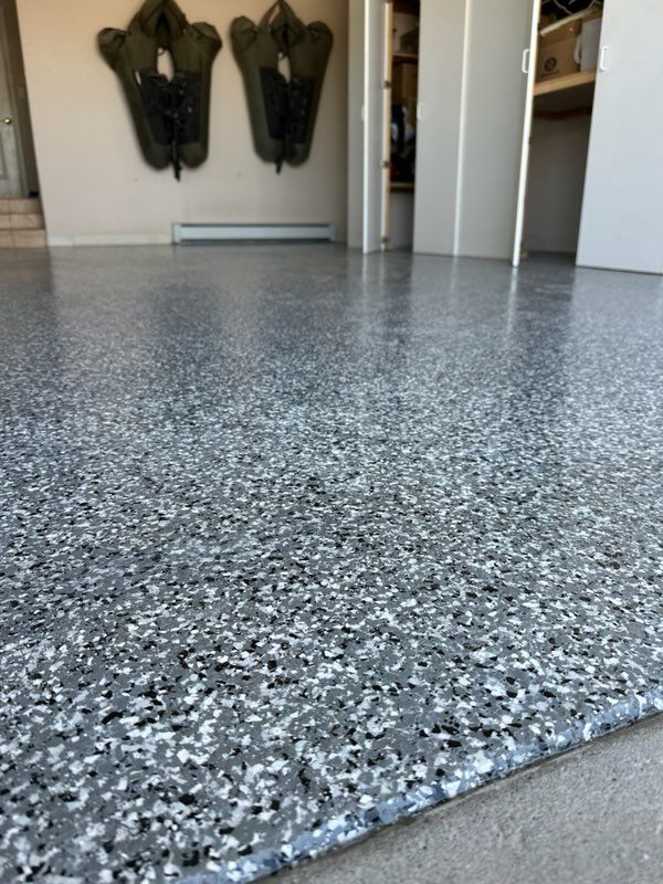 A close up of a gray and white floor in a garage.