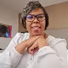 A man with dreadlocks and a beard is smiling for the camera