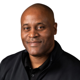 A bald man wearing a black shirt is smiling for the camera