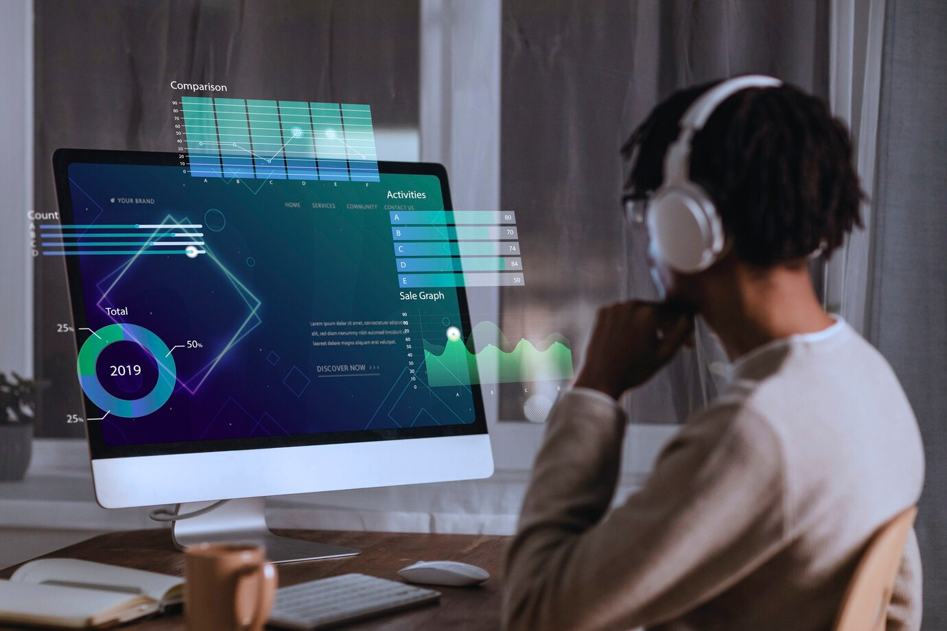 A man wearing headphones is sitting in front of a computer.