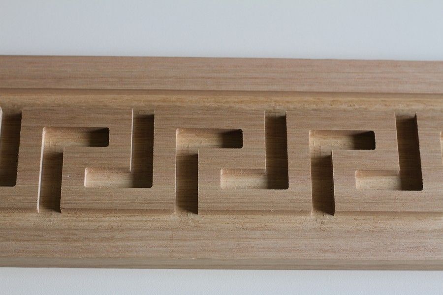 A piece of wood with a maze pattern carved into it