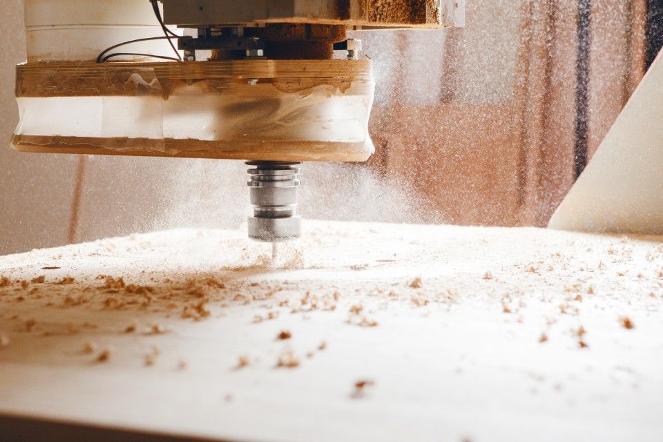 A machine is cutting a piece of wood on a table.