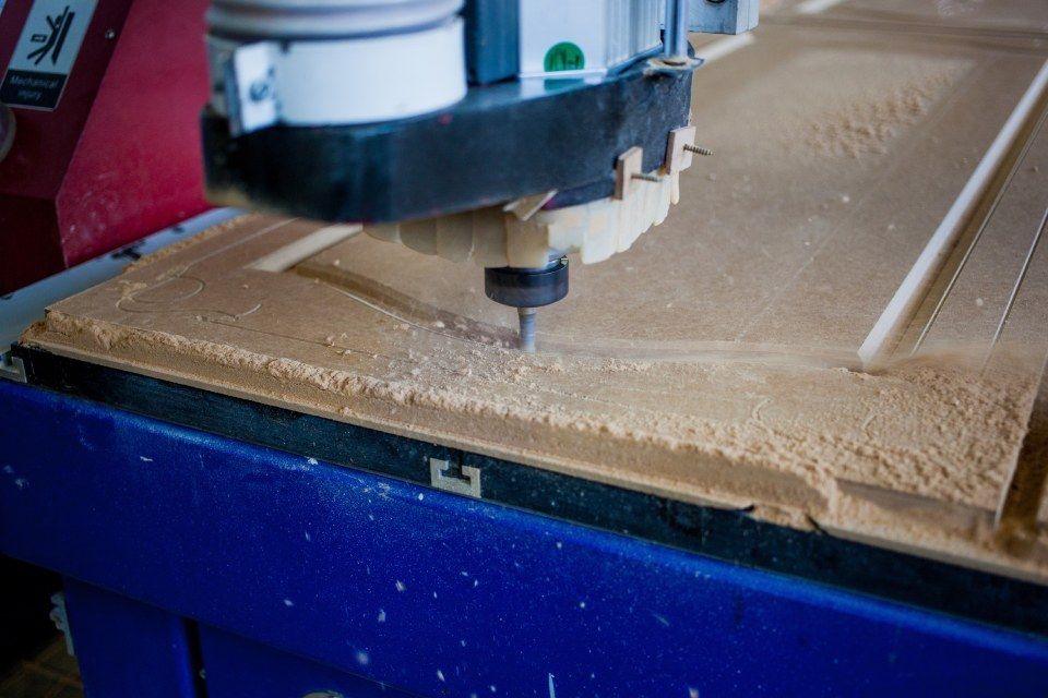 A machine is cutting a piece of wood on a table.