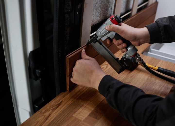 A man is installing furniture in a vehicle.