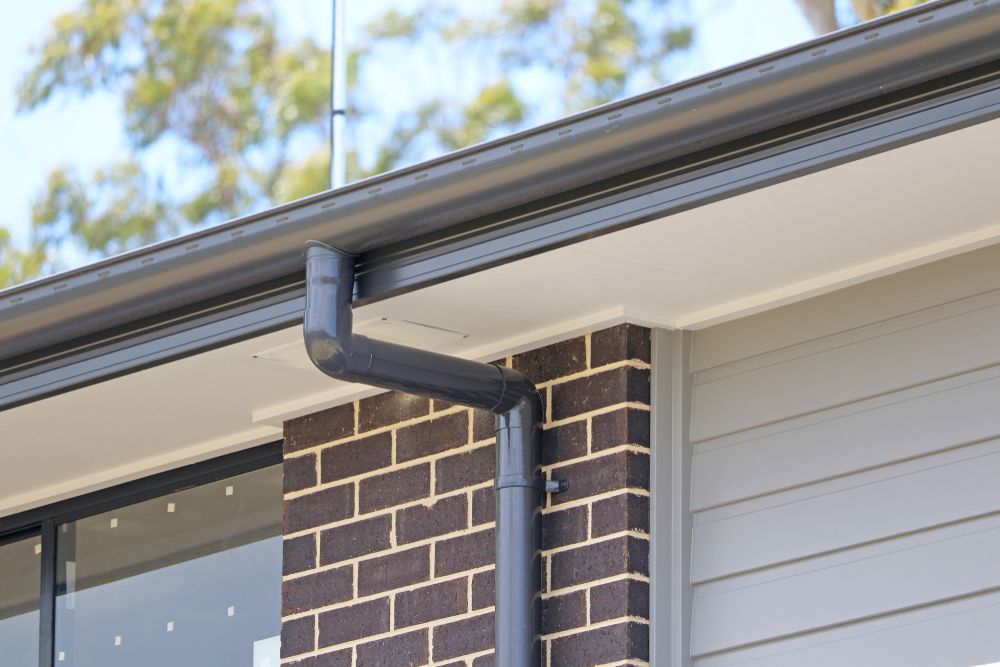 Dark Gray Gutters and Downspout on A House with Brick and Siding — All-Clear Gutter Guard NQ in Speewah, QLD