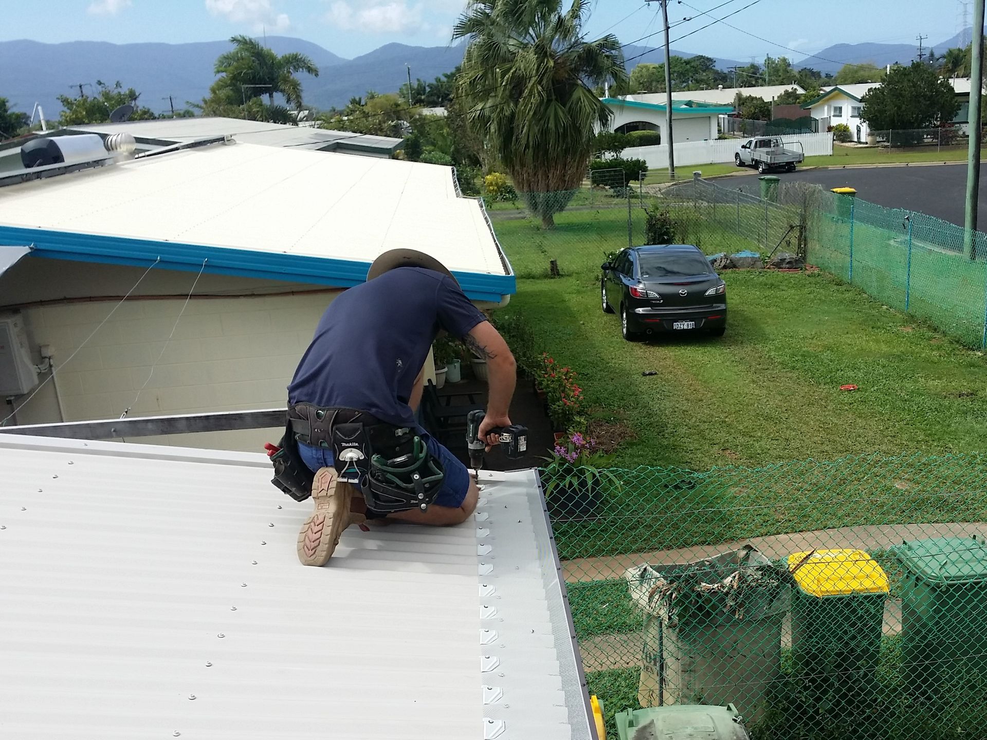 A Man is Working on the Roof of a House — All-Clear Gutter Guard NQ in Cairns, QLD