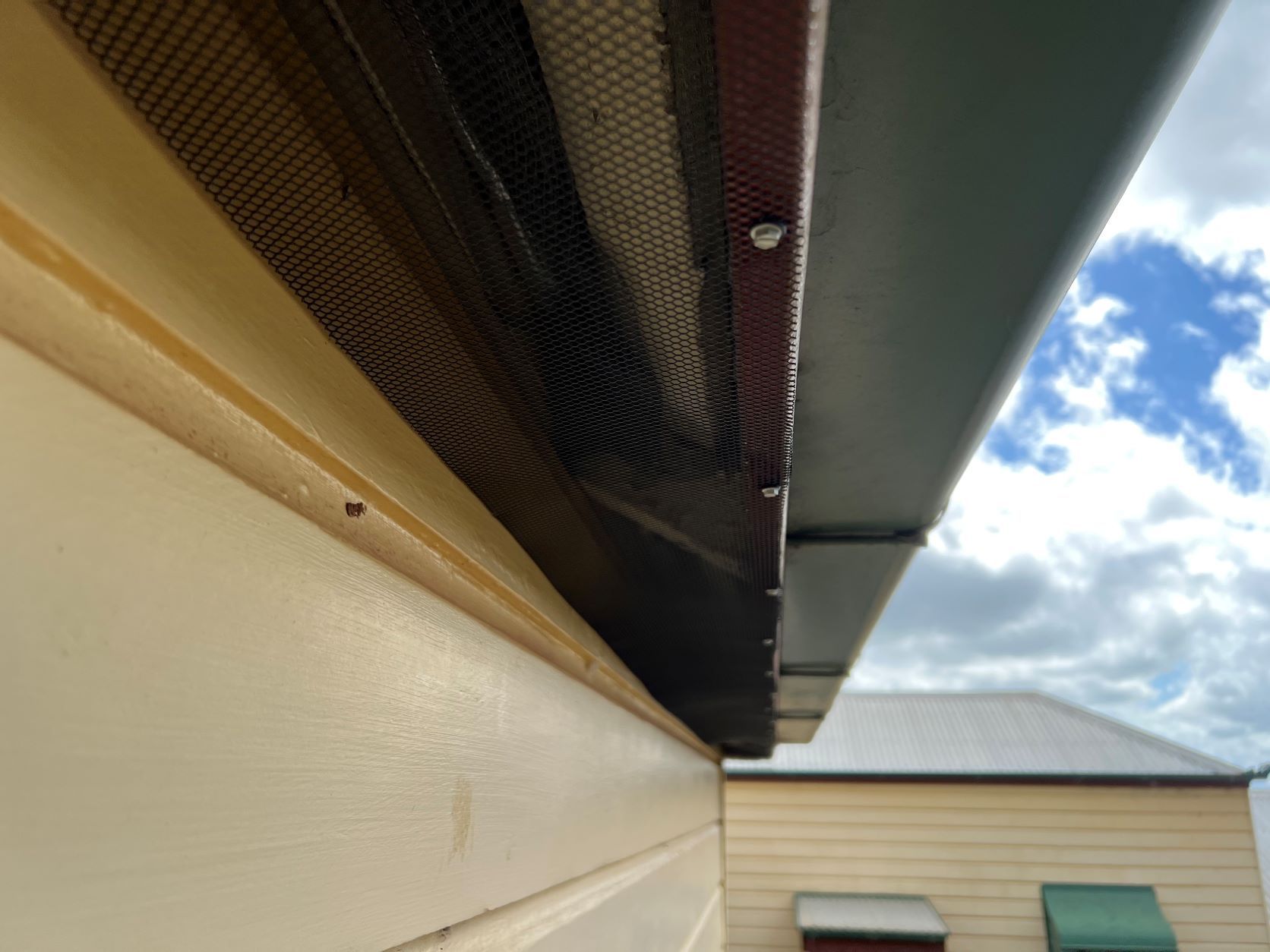 Black Mesh Gutter Guard Installed on A House, Under a Dark Gray Gutter — All-Clear Gutter Guard NQ in Tolga, QLD