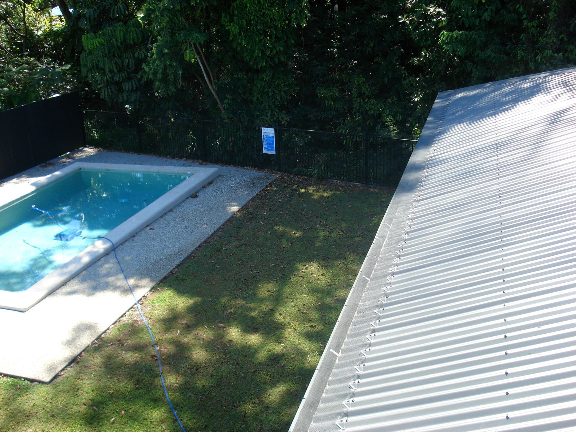 Pool and Yard Next to A Corrugated Metal Roof — All-Clear Gutter Guard NQ in Babinda, QLD