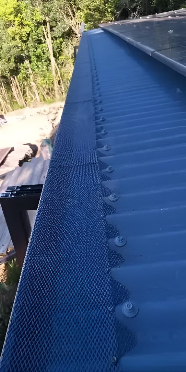 Close-Up of A Blue Corrugated Metal Roof with A Mesh Gutter Guard, Secured with Bolts — All-Clear Gutter Guard NQ in Tully, QLD